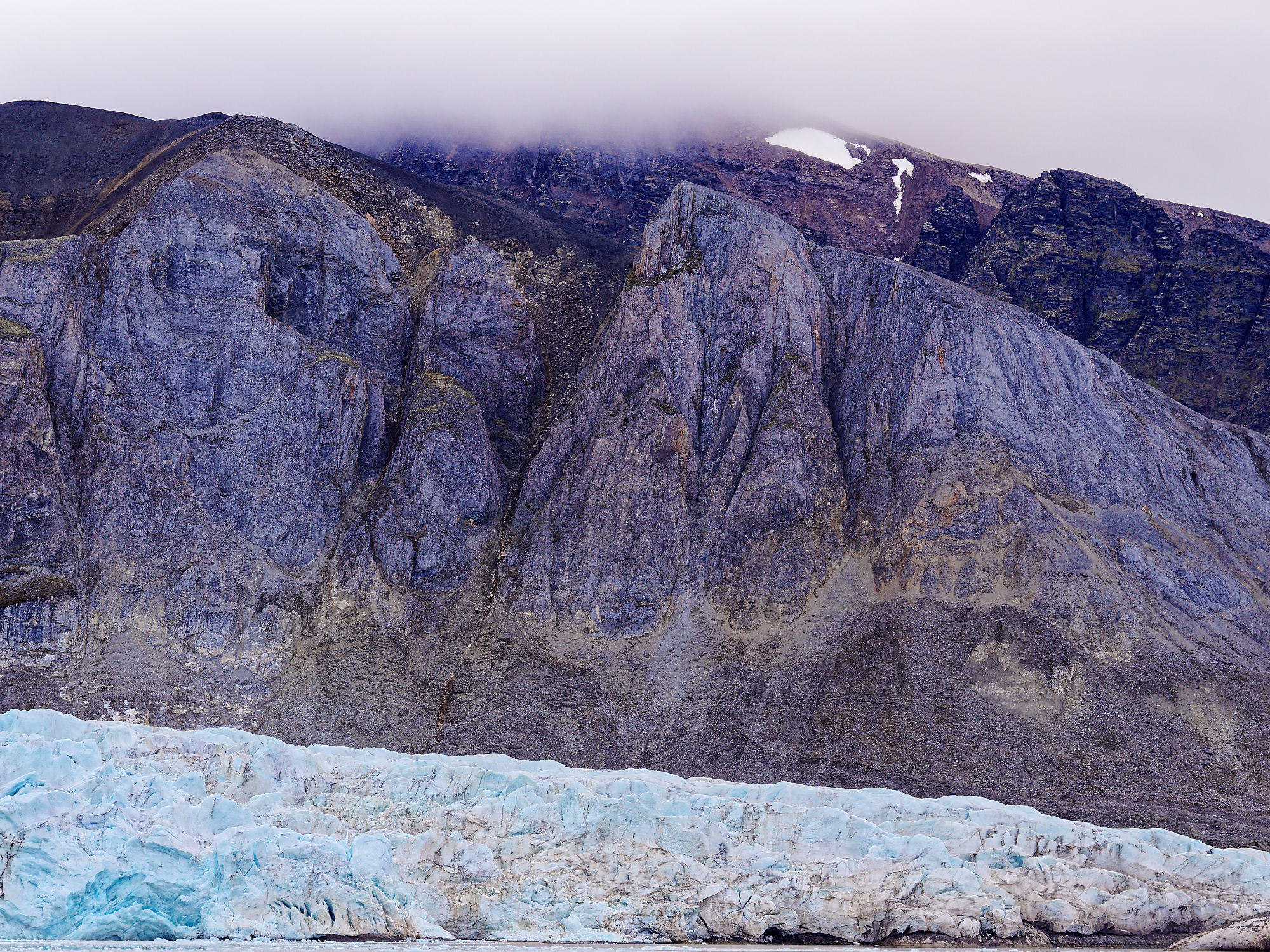Eisige Gletscherfront im Woodfjorden, Spitzbergen. Schroffe Berge im Hintergrund. Arktische Landschaft.