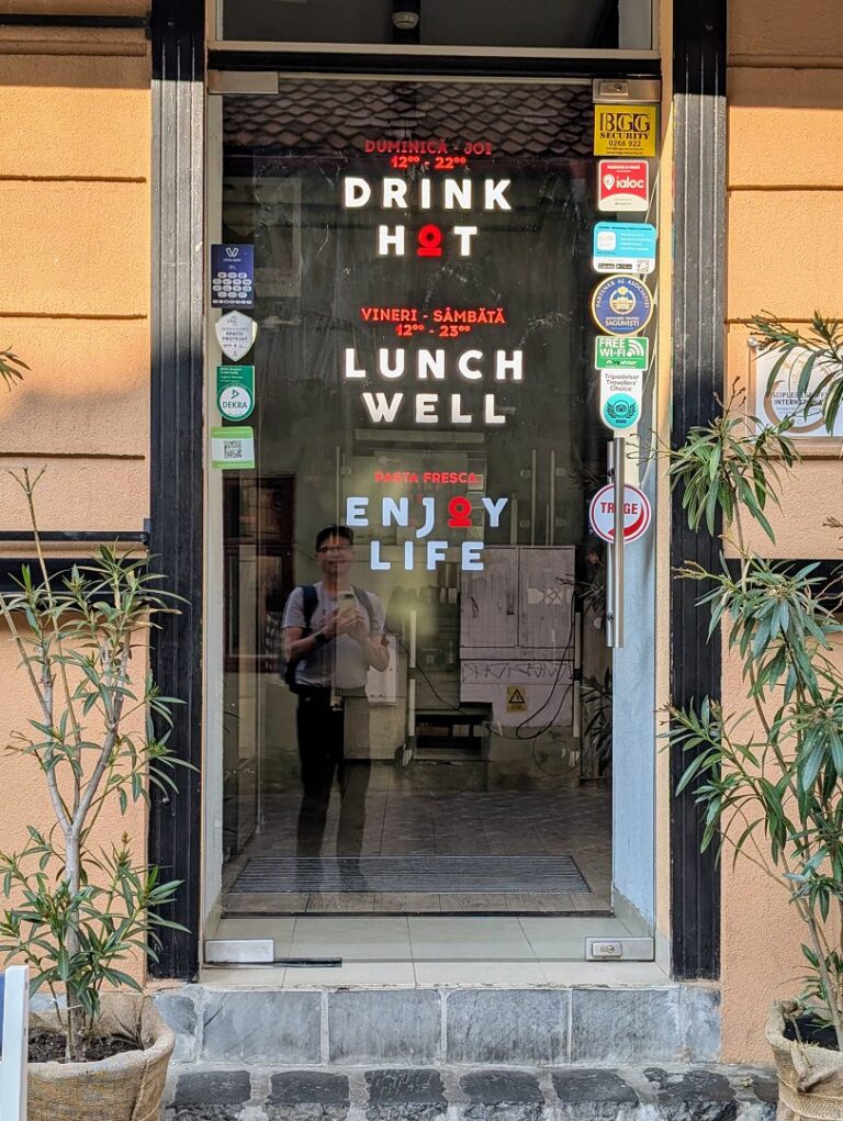 Brasov Restaurant: Eingangstür mit Aufschrift Drink Hot, Lunch Well, Enjoy Life.