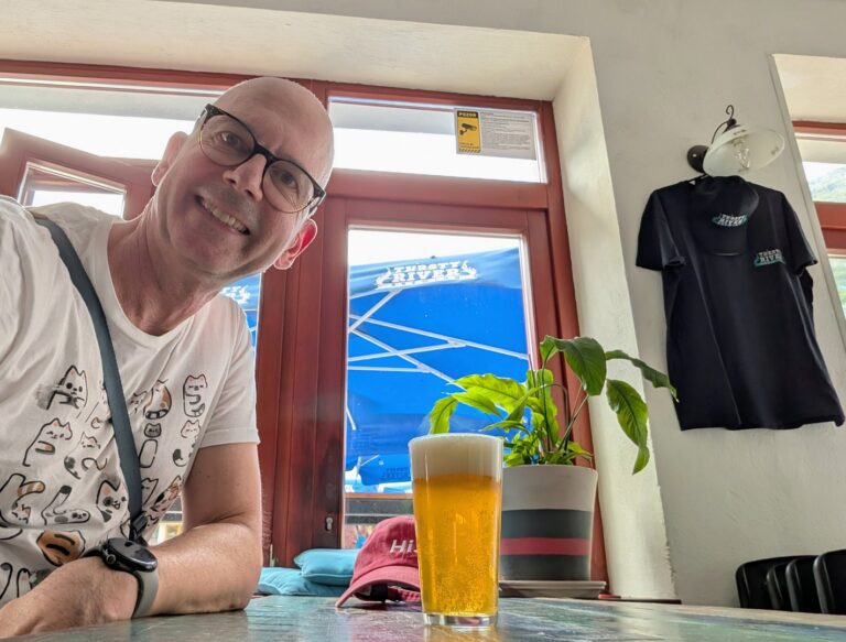 Mann mit Bier im Thirsty-River-Pub, T-Shirt und Cap im Hintergrund. Craft-Beer. Urlaub.