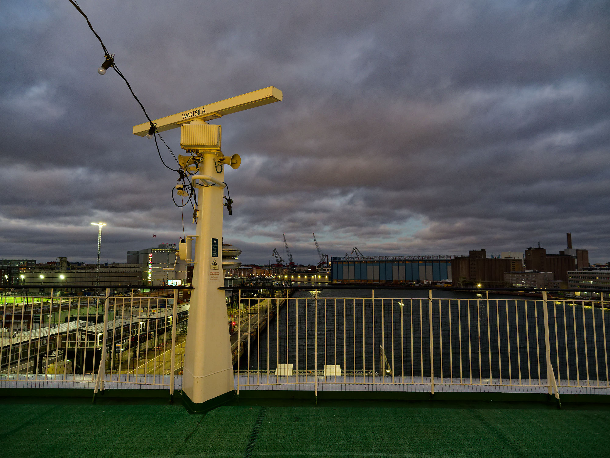 Blick von Fähre auf Helsinki Hafen bei Nacht. Radar und Reling im Vordergrund. Finnland Reise.