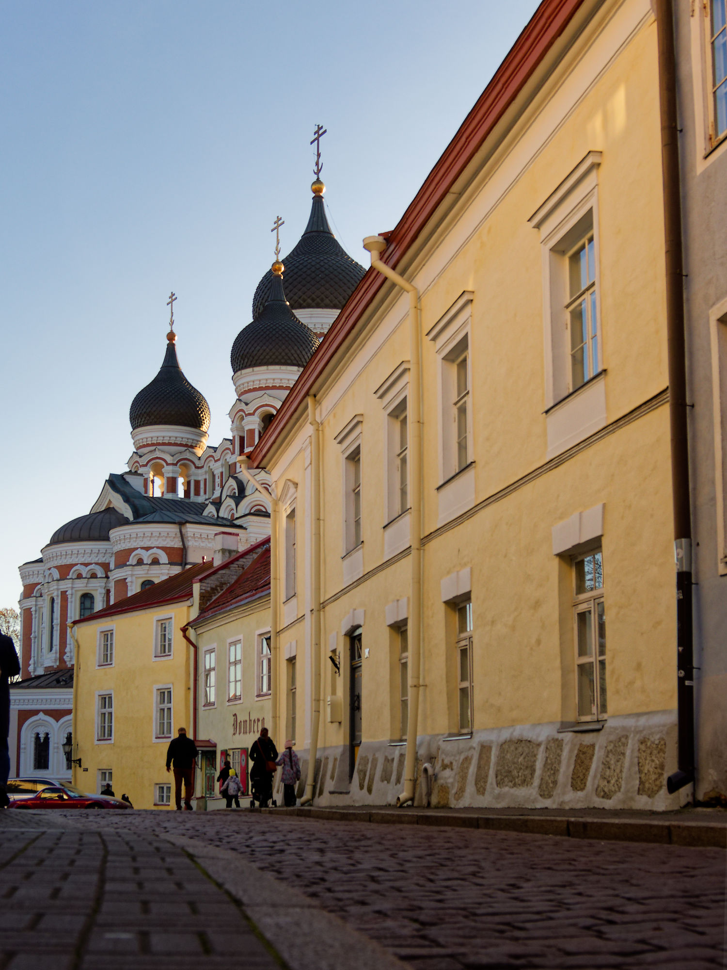 Tallinn Altstadt: Alexander-Newski-Kathedrale Kuppeln und gelbe Gebäude an Kopfsteinpflasterstraße. Estland Reise.