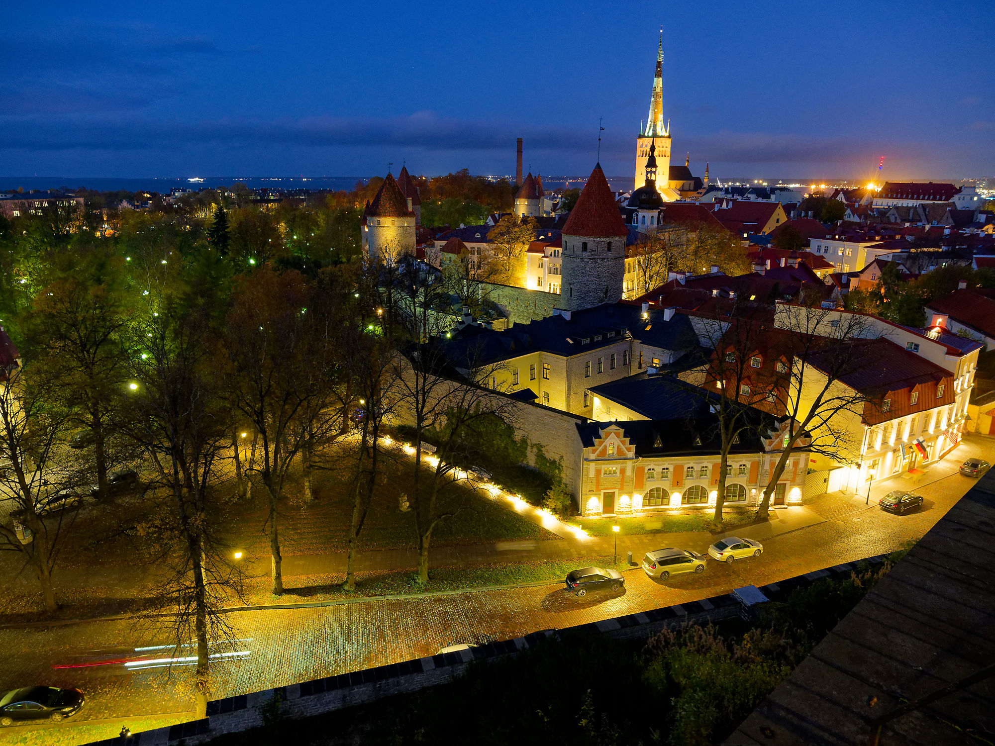 Tallinn Altstadt bei Nacht: Mittelalterliche Türme, beleuchtete Gebäude und Kopfsteinpflaster. Estland Reiseziel.