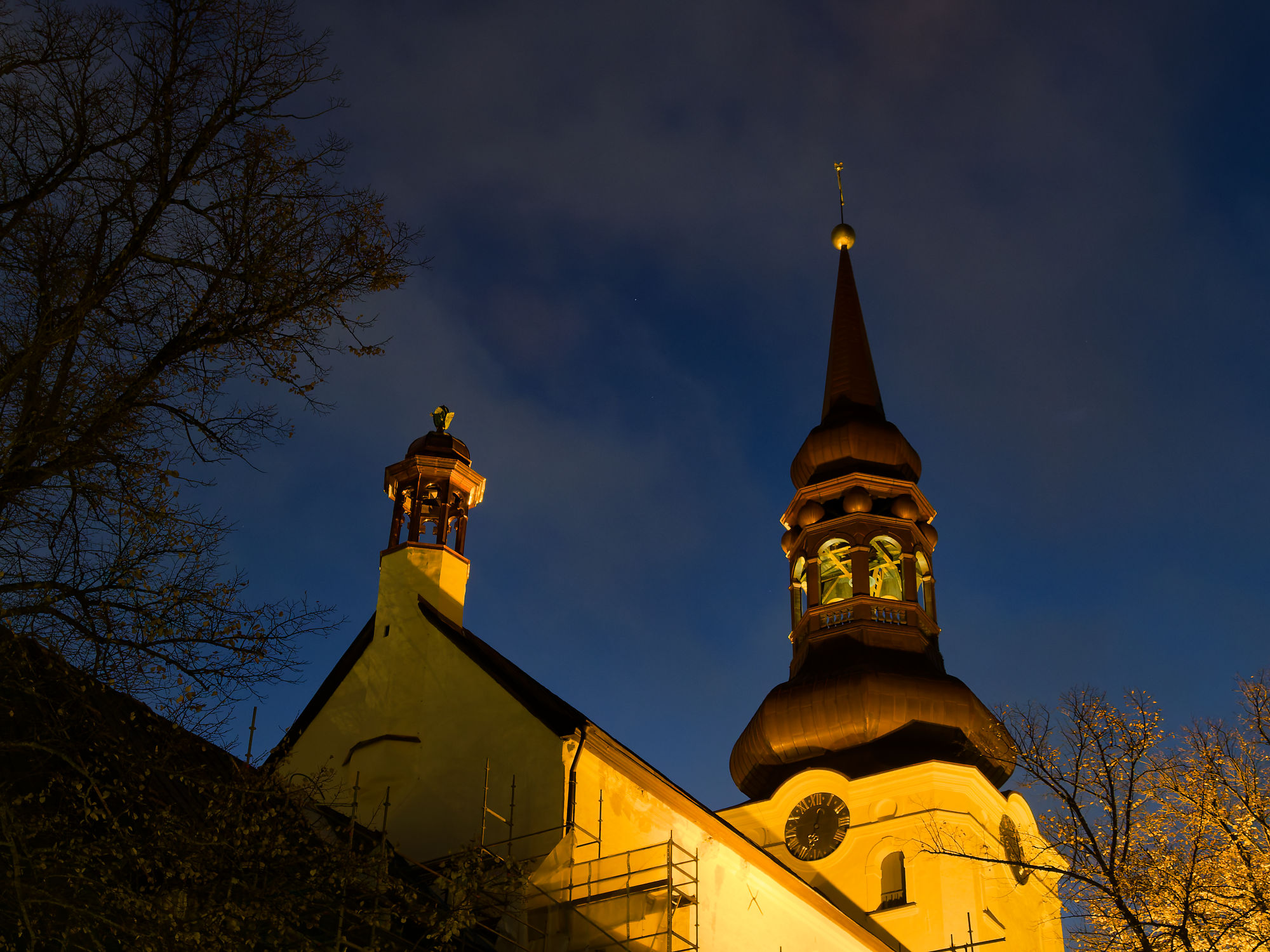 Tallinn bei Nacht: Kirche mit Turm und Uhr. Architektur und Stadtbild in Estland.