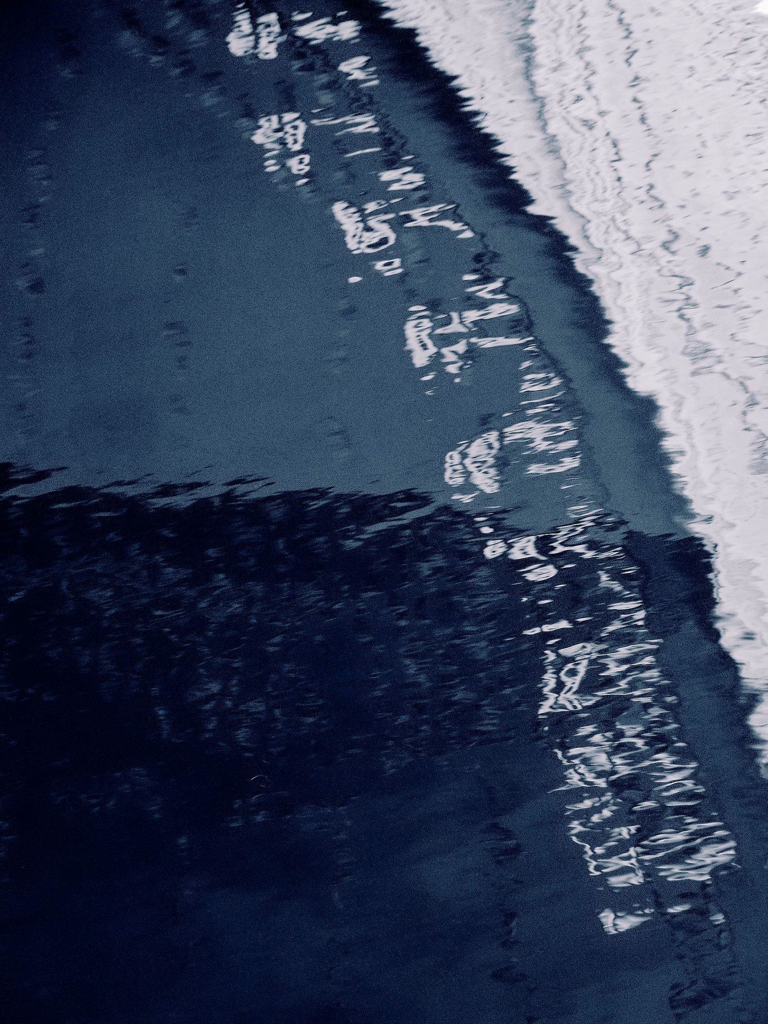 Abstraktes Wasserbild, Tallinn. Dunkelblaues Wasser mit weißen Reflexionen. Küstenlinie.