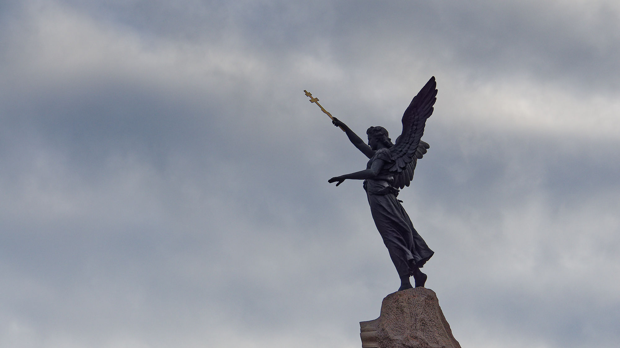 Russalka-Denkmal in Tallinn, Estland. Statue mit goldenem Kreuz auf einem Felsen gegen bewölkten Himmel. Sehenswürdigkeit.