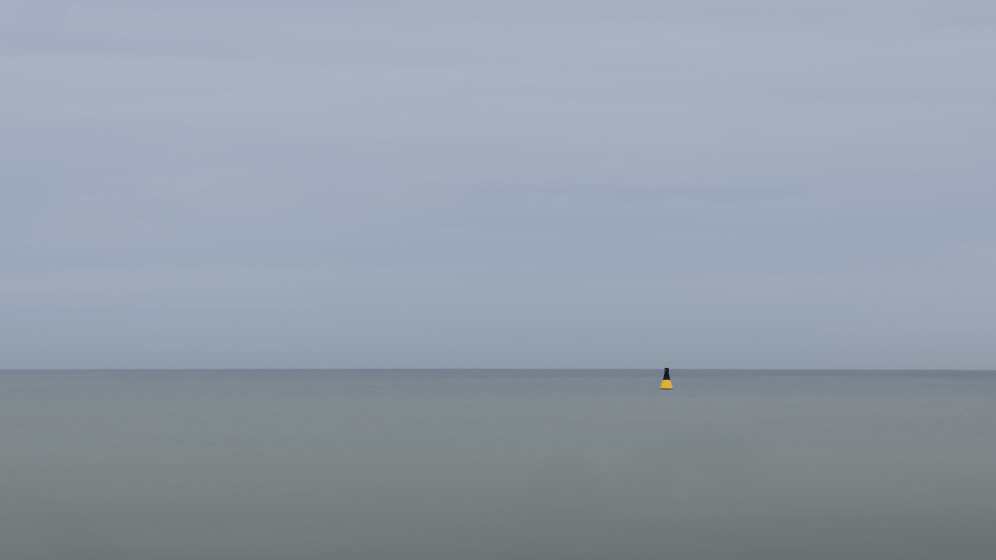 Gelbe Boje im ruhigen Meer, Tallinn. Minimalistisch, Ostsee. Langzeitbelichtung