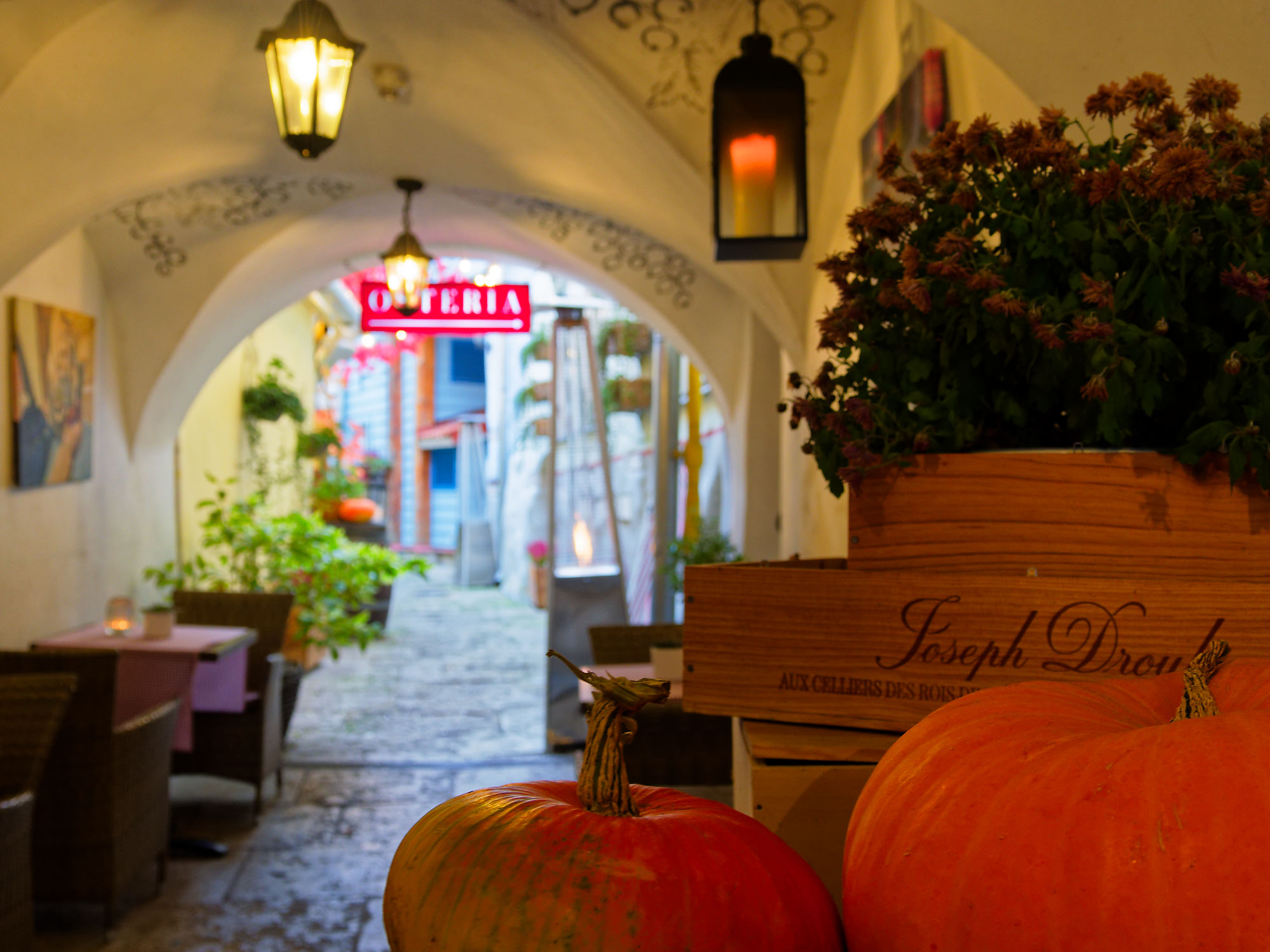 Herbstdeko in Tallinn: Kürbisse, Laternen und das Osteria-Schild in der Altstadt. Romantische Atmosphäre.