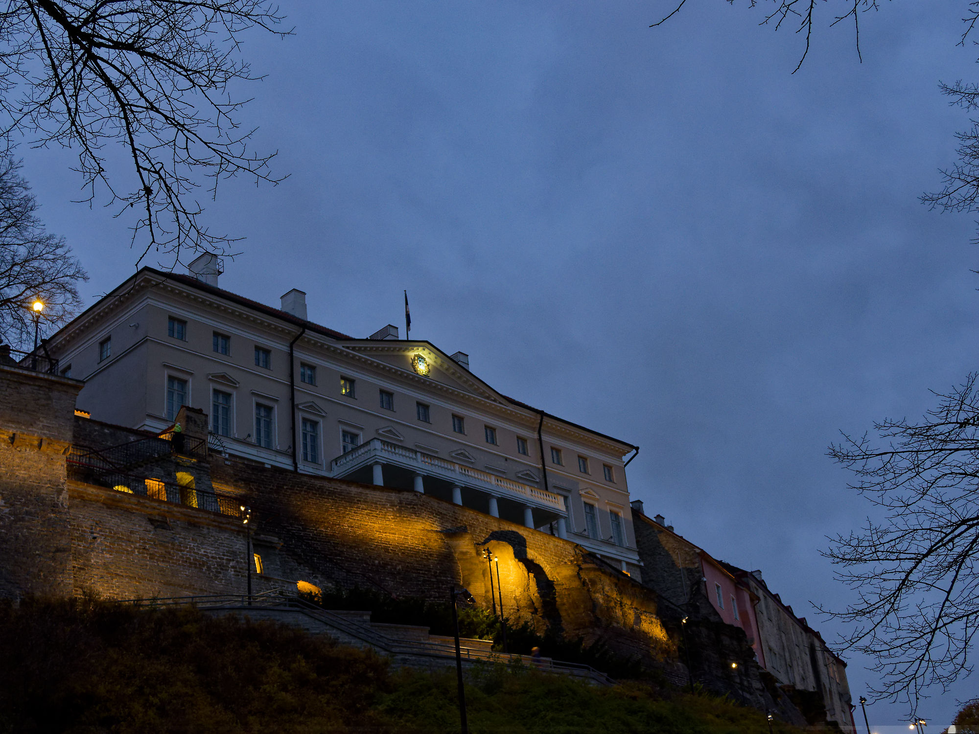 Abendliche Ansicht von Schloss Tallinn, Estland. Beleuchtete Steinmauer und dunkler Himmel. Sehenswürdigkeit.