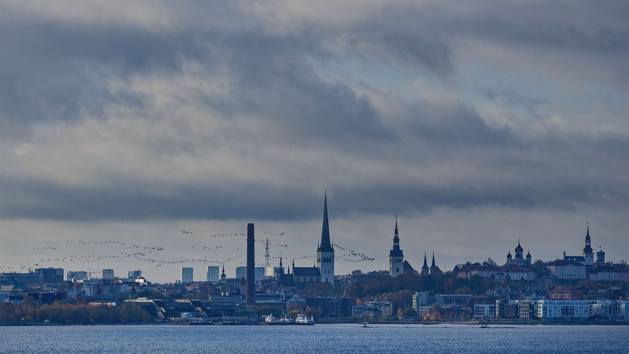 Skyline von Tallinn, Estland, mit mittelalterlichen Türmen und Wolken über der Ostsee.