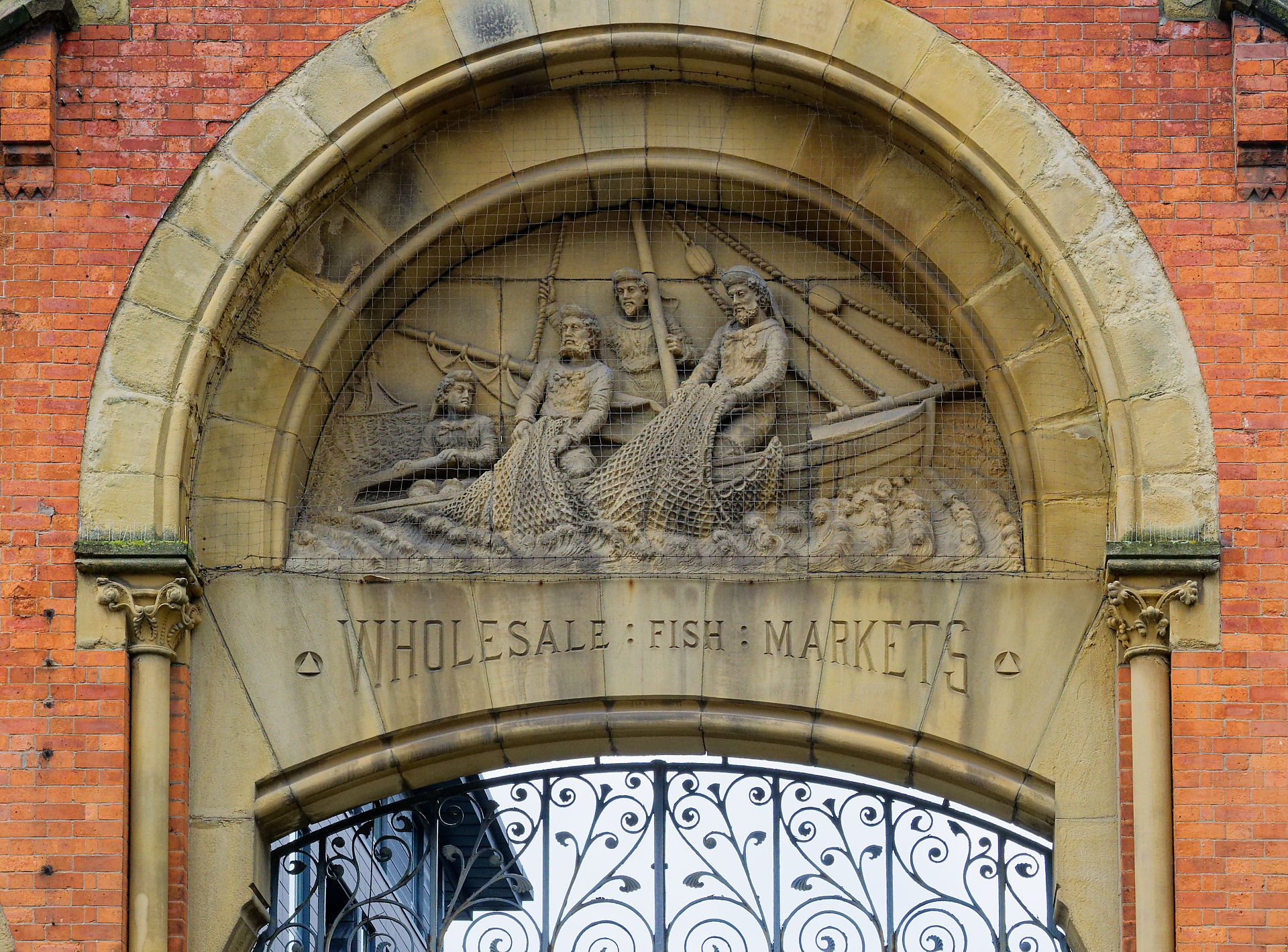 Manchester Skulptur von Fischern in einem Boot über dem Eingang zu den Wholesale Fish Markets in Manchester.