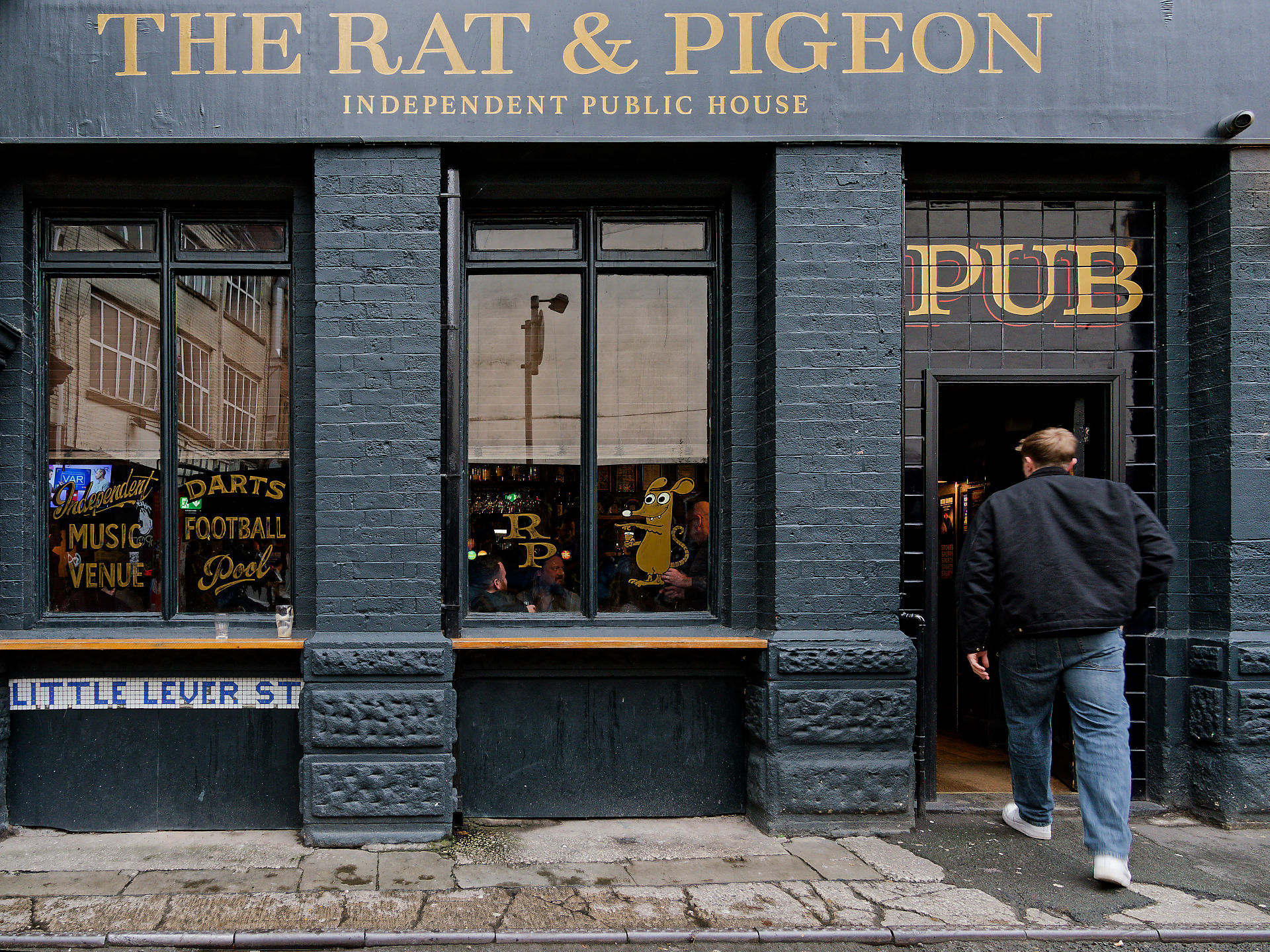 Manchester Manchester Pub "The Rat & Pigeon" mit Fassade, Schildern und Person am Eingang. Independent Public House.