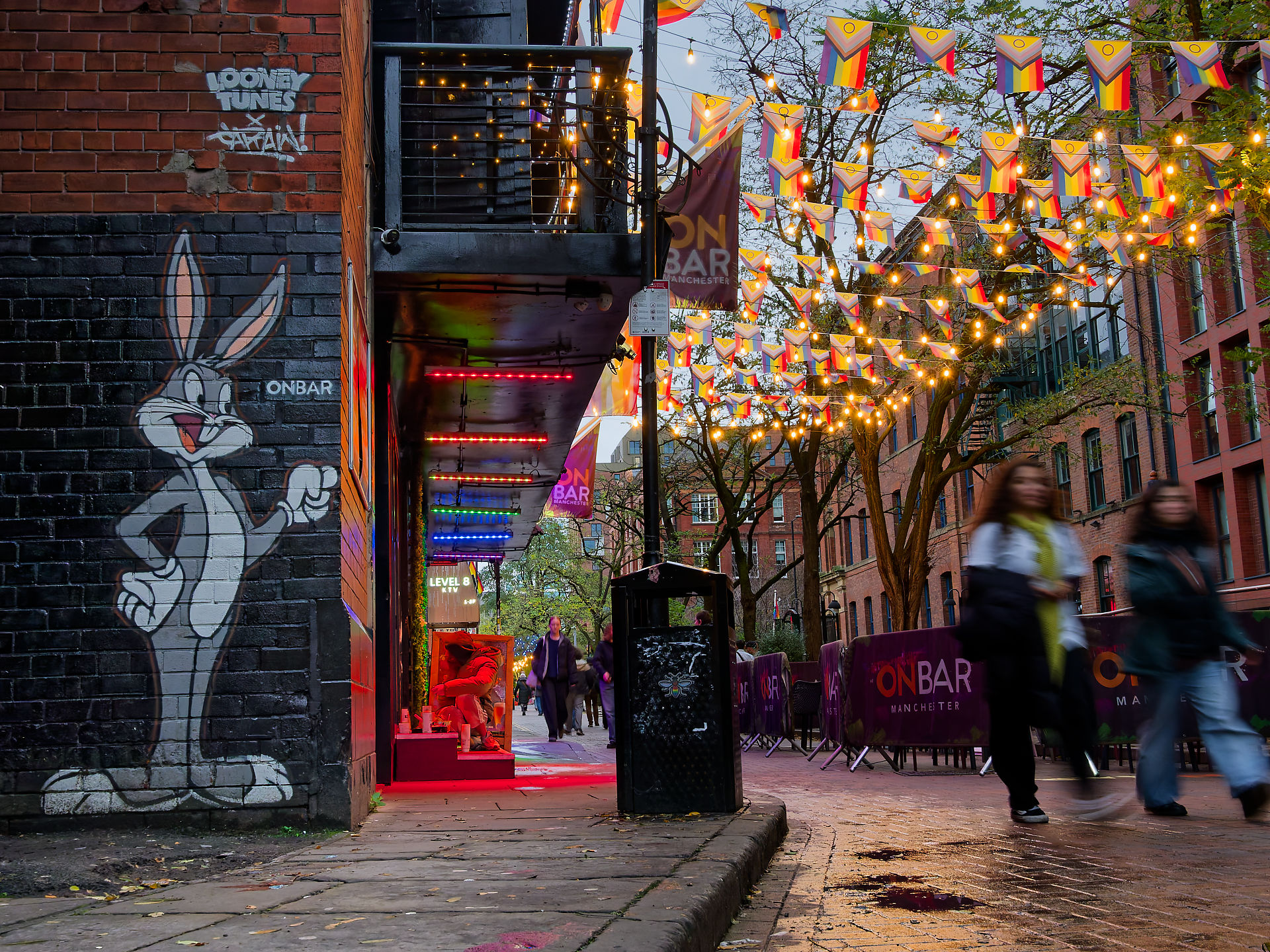 Manchester Manchester Bar Szene: Bugs Bunny Graffiti, Regenbogenflaggen und Lichterketten schaffen ein lebhaftes Stadtbild.