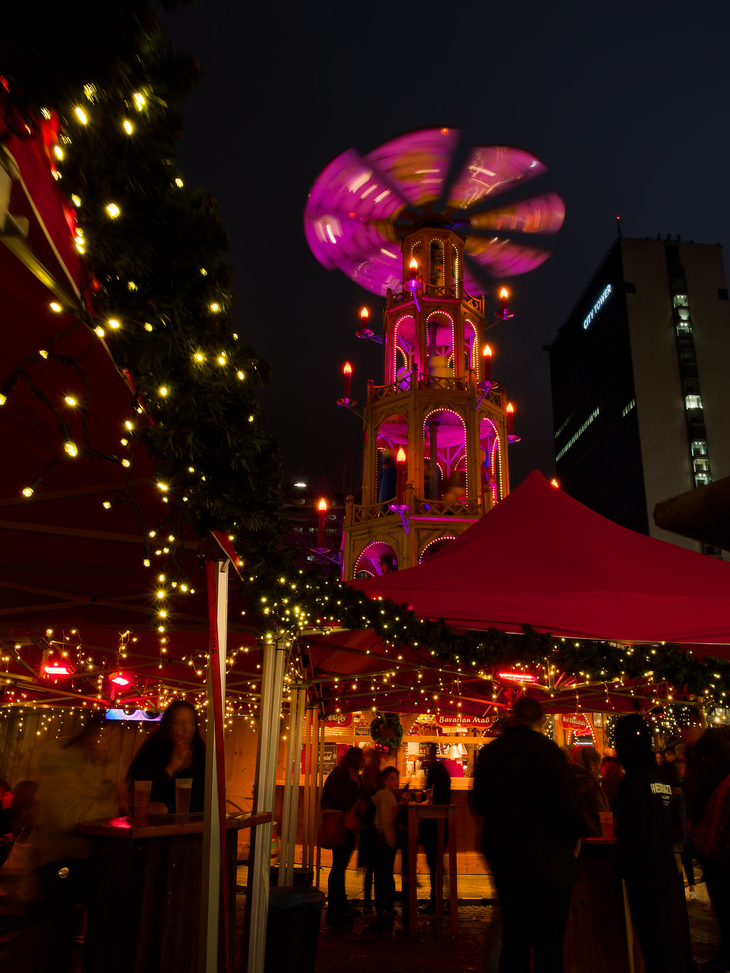 Manchester Manchester Weihnachtsmarkt mit Pyramide und Lichtern. Stimmungsvolle Nachtaufnahme.
