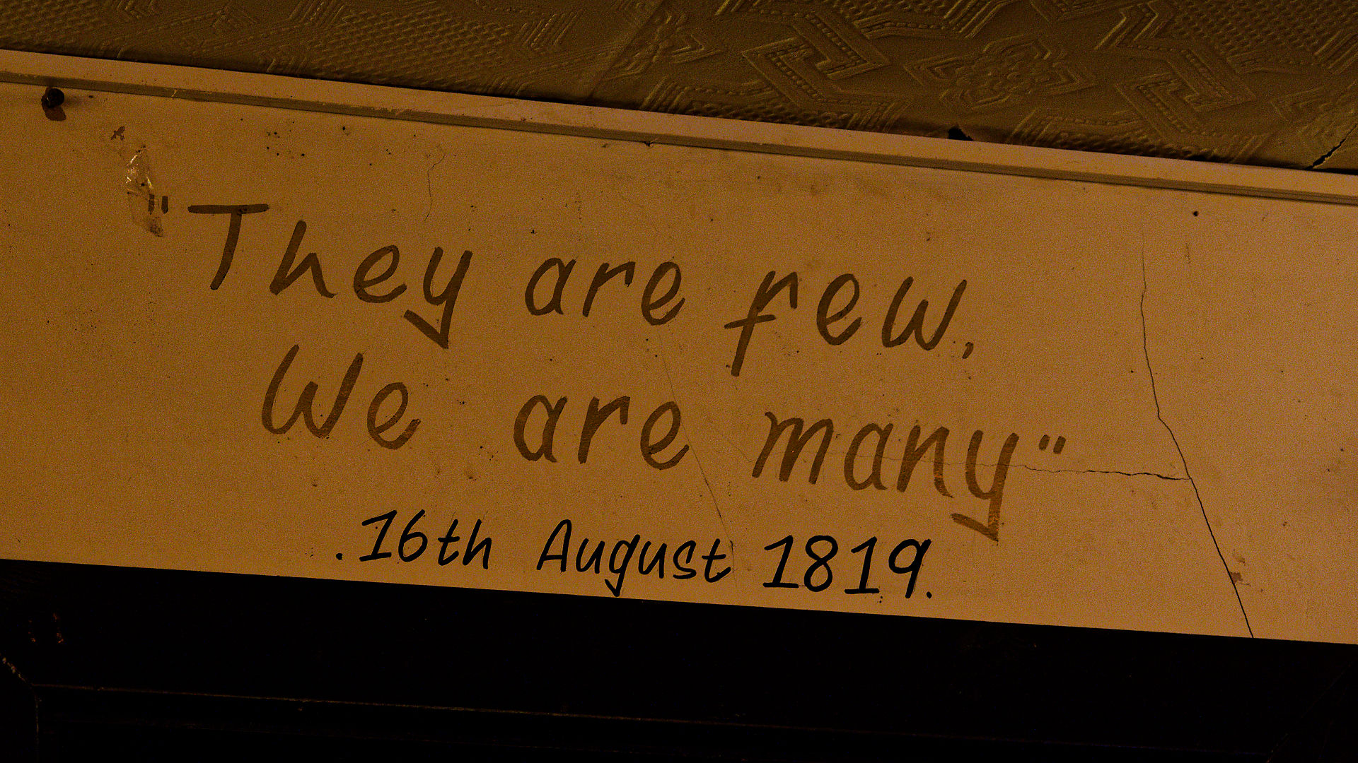 Manchester Manchester: Textschild mit Zitat "They are few. We are many." und Datum 16. August 1819.