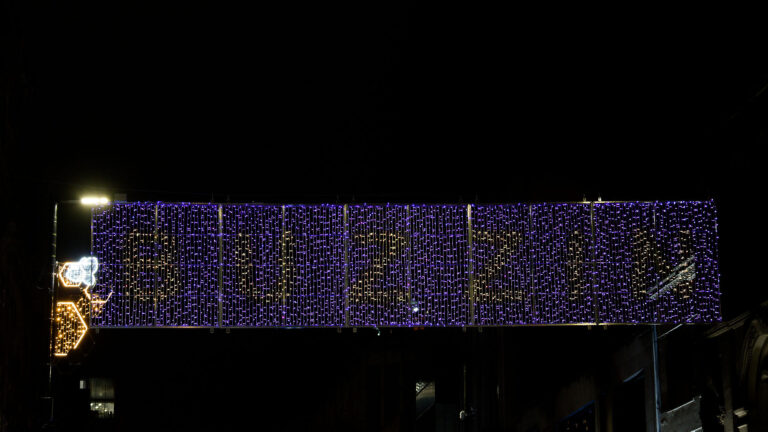Manchester Weihnachtsbeleuchtung: Lichterkette mit Sternen und festlicher Dekoration in der Nacht.