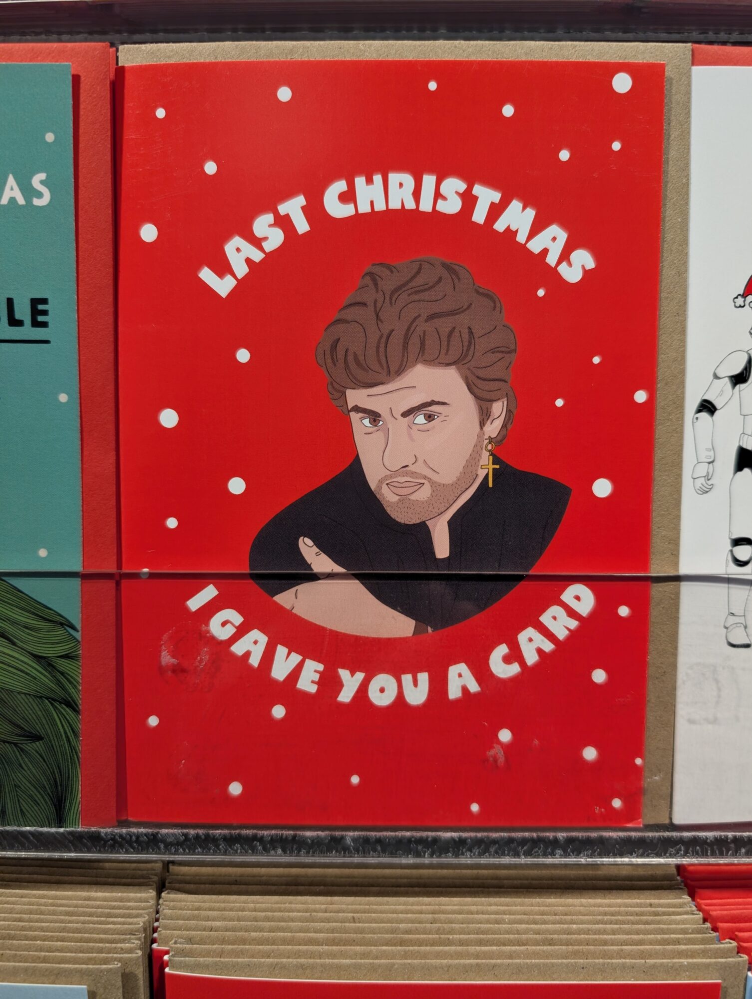 Manchester Weihnachtskarte mit George Michael Zitat. Rote Karte mit Schneeflocken und dem Text: Last Christmas I gave you a card.