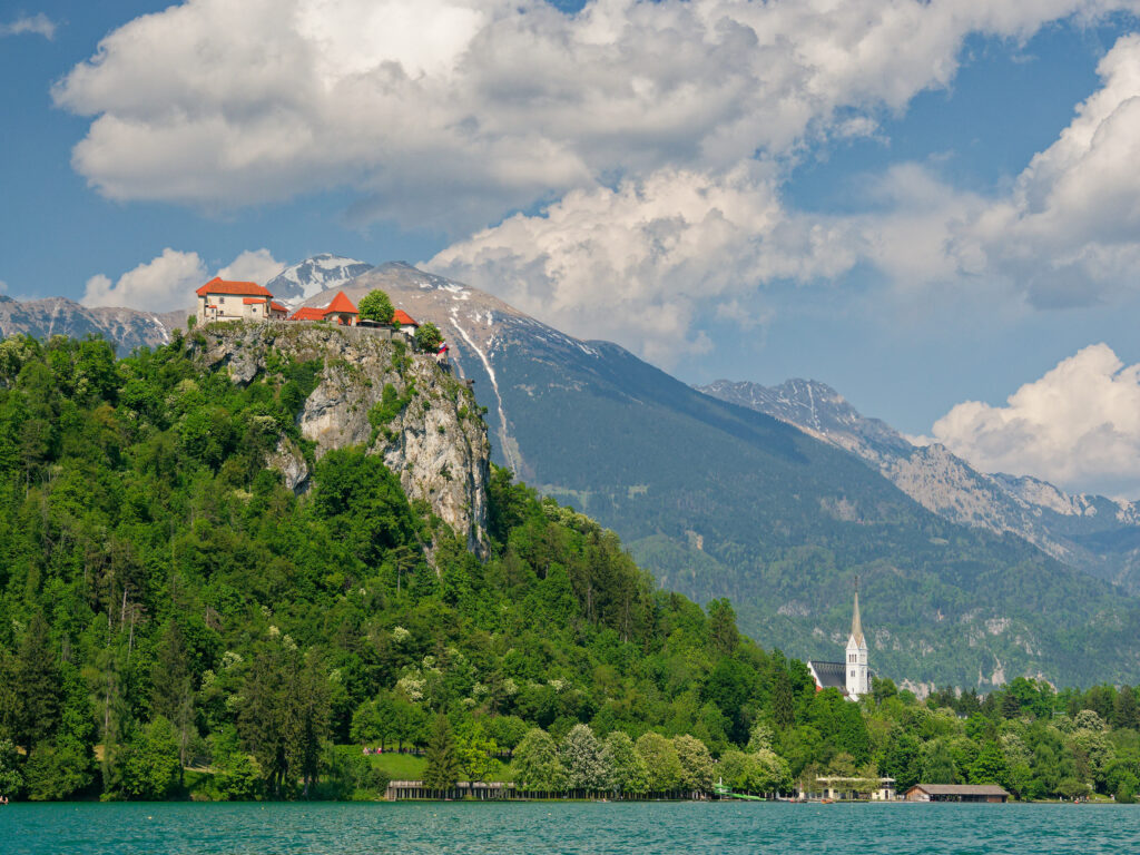Bled See, Slowenien: Burg auf Felsen, Kirche, Alpenpanorama. Idyllische Landschaft.