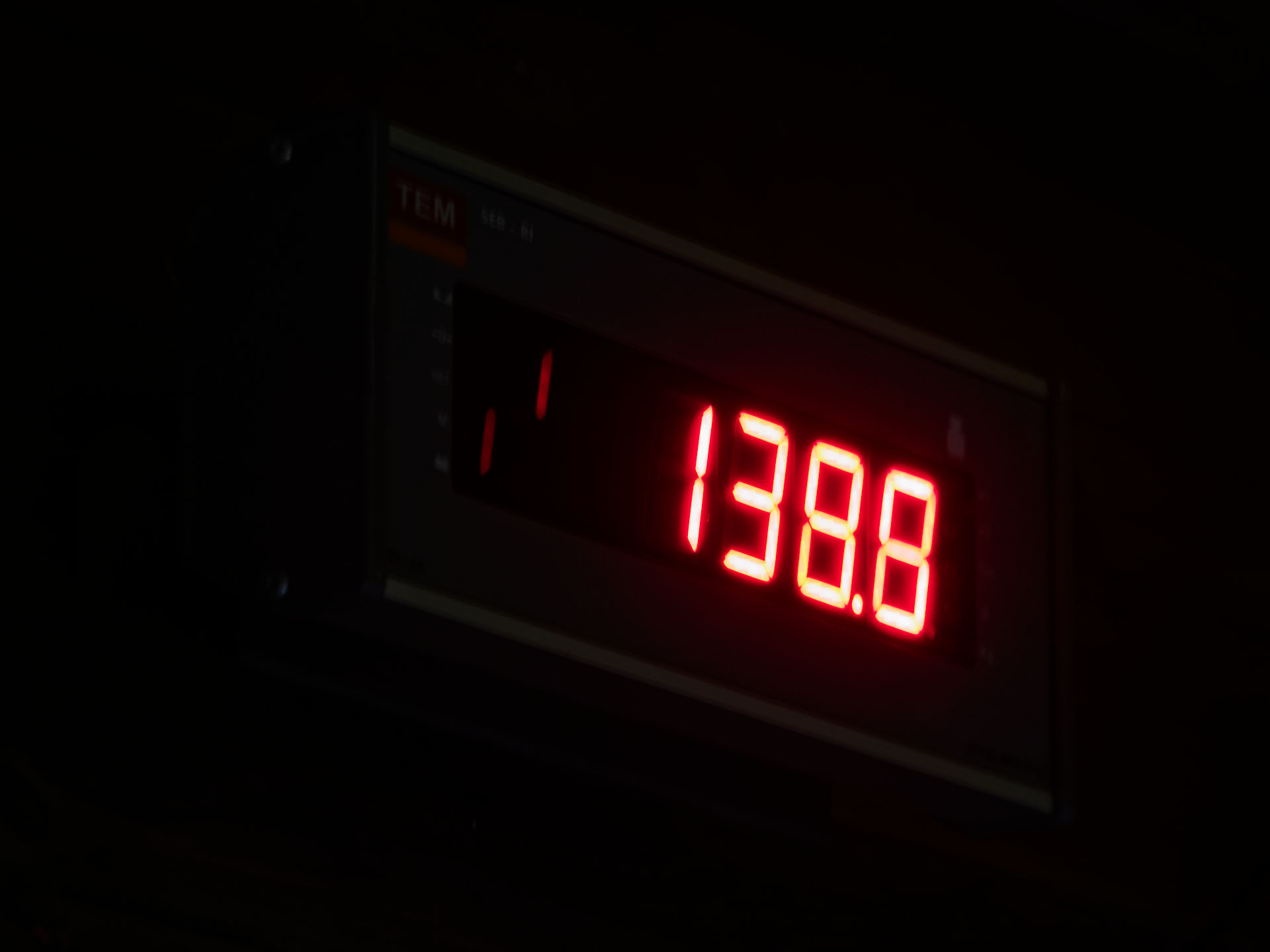Rote Digitalanzeige zeigt 138.8. Elektronisches Messgerät im Dunkeln.