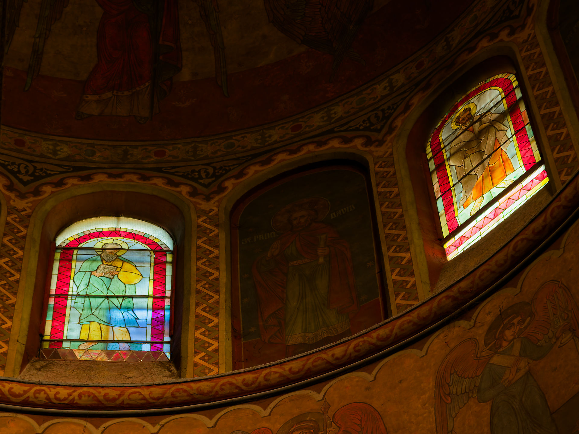 Biserica Adormirea Maicii Domnului: Buntglasfenster und religiöse Wandmalereien in rumänischer Kirche.