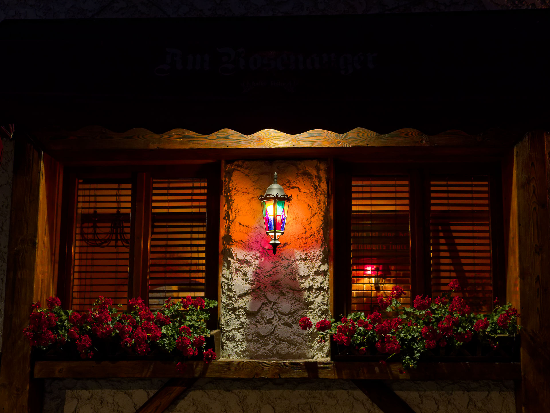 Fenster in Brasov, Rumänien, mit Blumen, Lampe und Holzrahmen. Romantische Atmosphäre. Reiseziel.