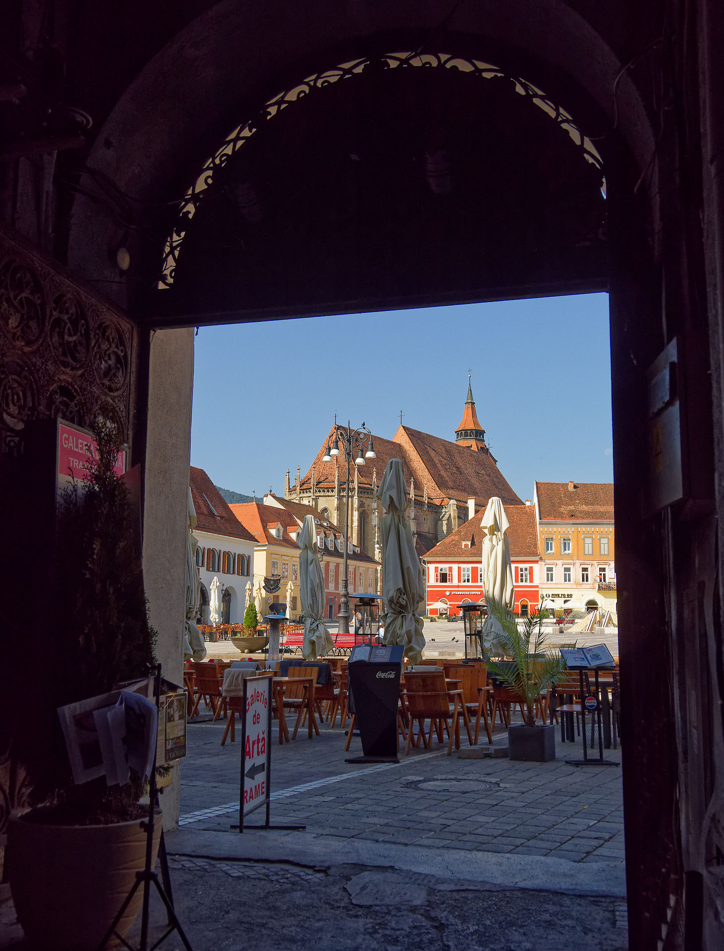 Brasov, Rumänien: Blick durch Torbogen auf den Rathausplatz mit Schwarzer Kirche. Touristische Attraktion.