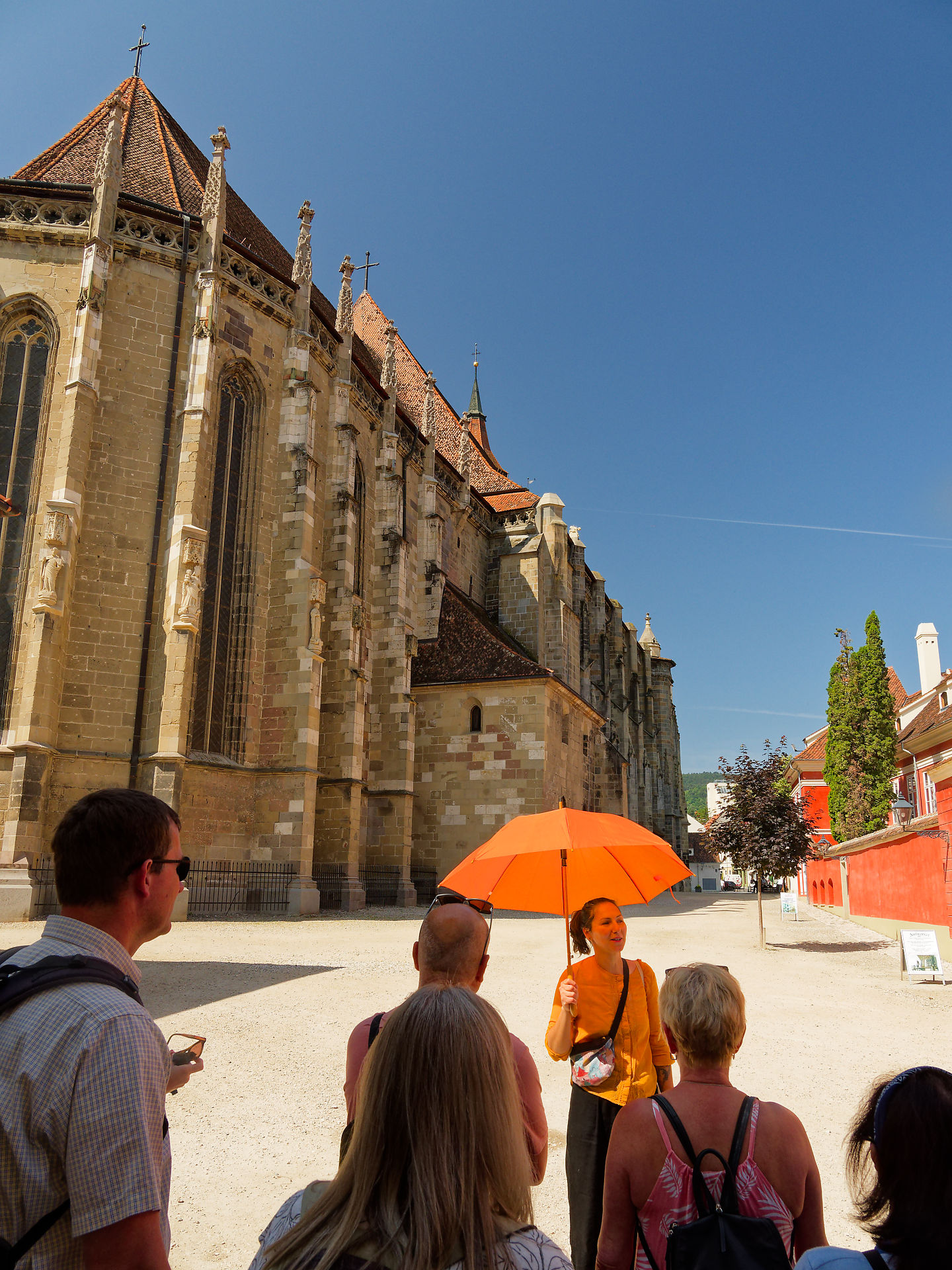 Führung in Brasov, Rumänien, vor der Schwarzen Kirche. Reiseleiterin mit Schirm. Sehenswürdigkeiten.