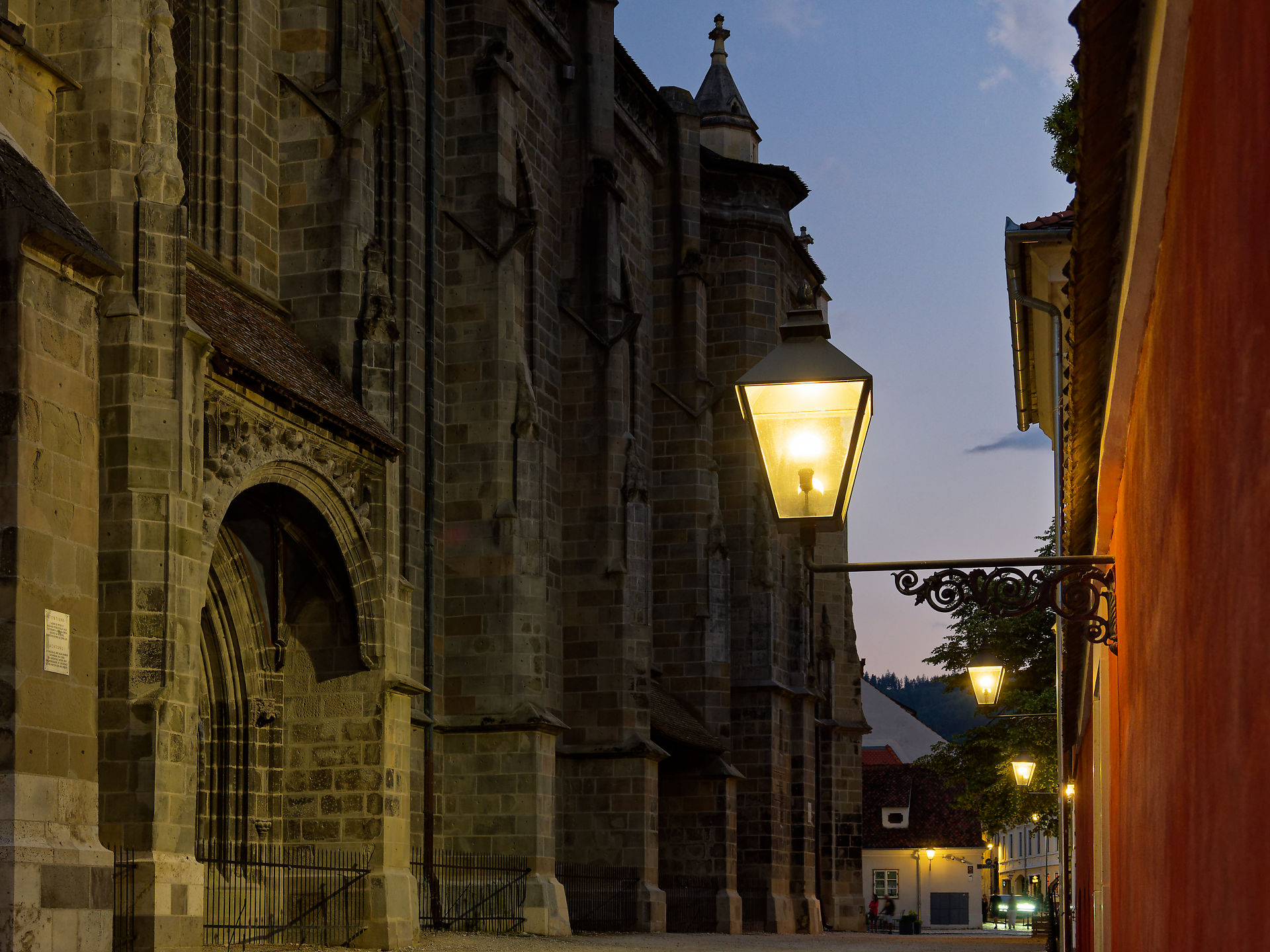 Abendliche Gasse in Brasov, Rumänien. Architektur mit alter Kirche und Laternen. Stimmungsvolle Stadtansicht.