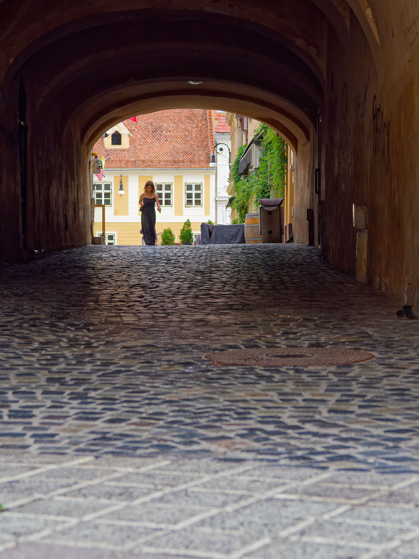 Frau im Durchgang, Brasov, Rumänien. Kopfsteinpflaster und historische Architektur. Reiseziel.