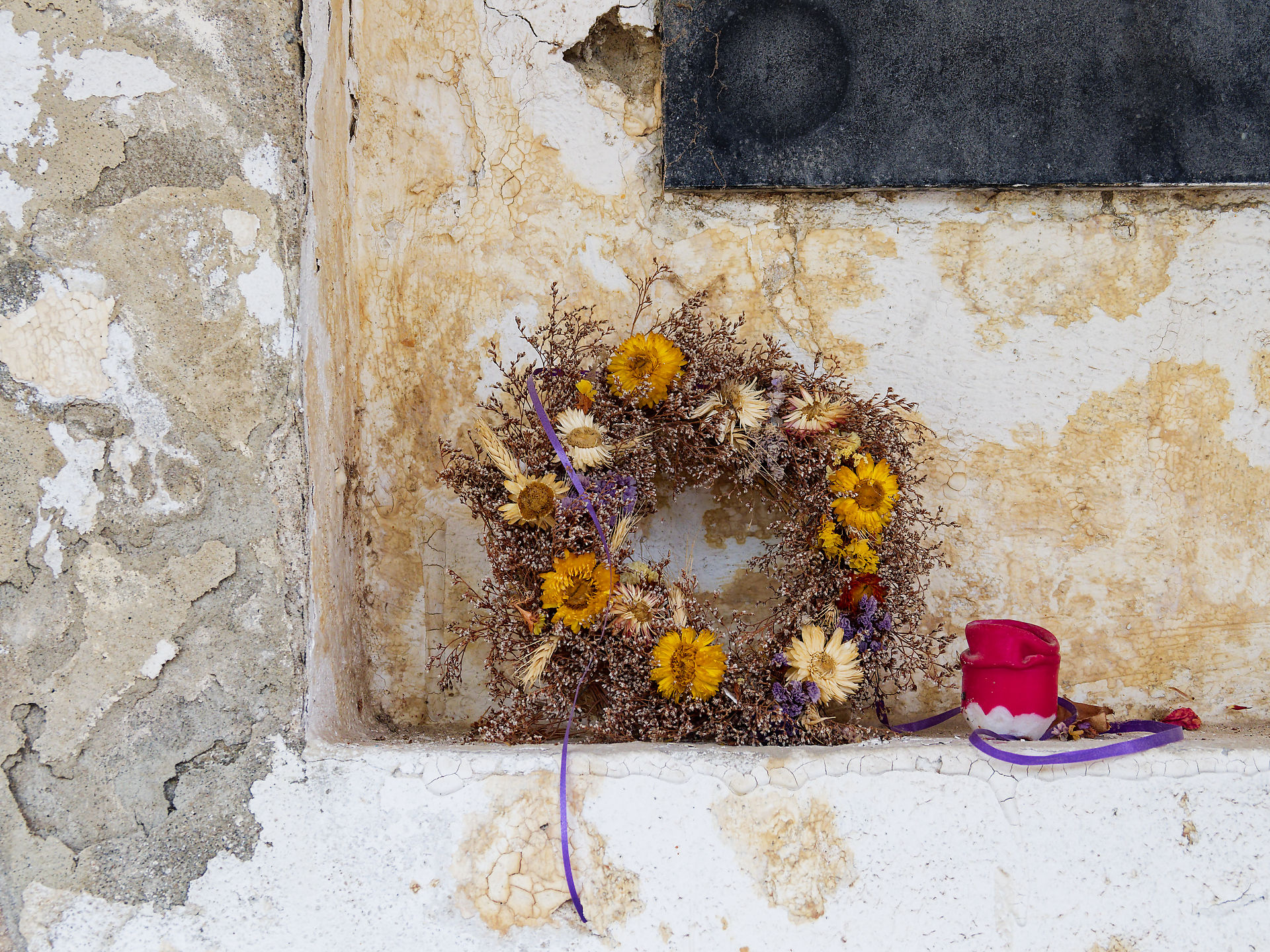 Blumenkranz und Kerze an alter Wand in Brasov, Rumänien. Traditionelle Dekoration, Reisefotografie.