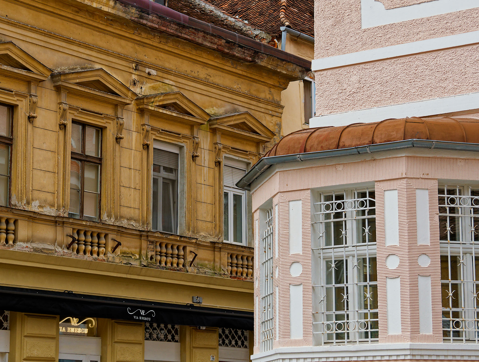 Architektur in Brasov, Rumänien. Fassaden mit Fenstern und Details. Gelbes und rosa Gebäude.