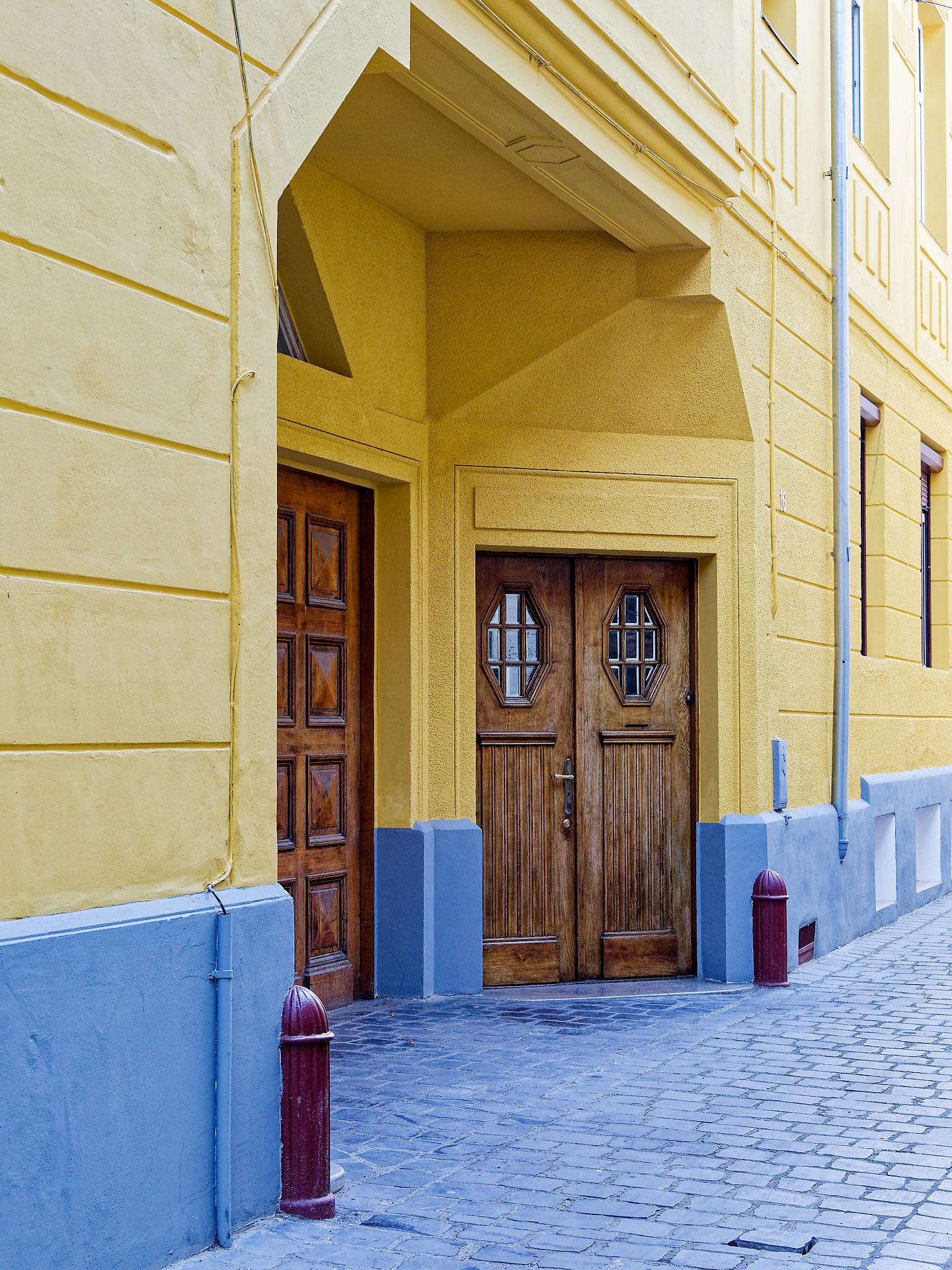 Gelbe Fassade mit Holztüren in Brasov, Rumänien. Architektur und Stadtbild.