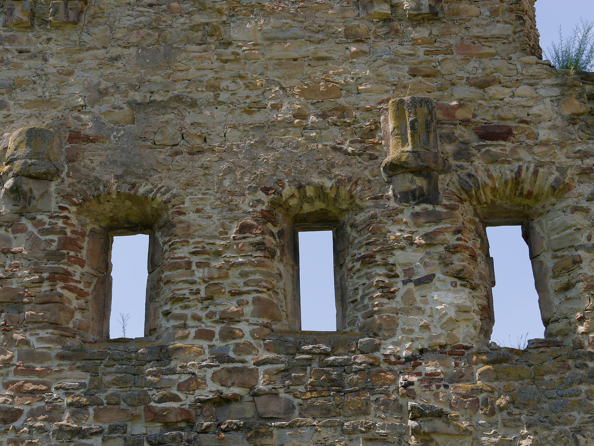 Ruine: Detailaufnahme einer alten Steinmauer mit drei Fensteröffnungen in Rumänien.