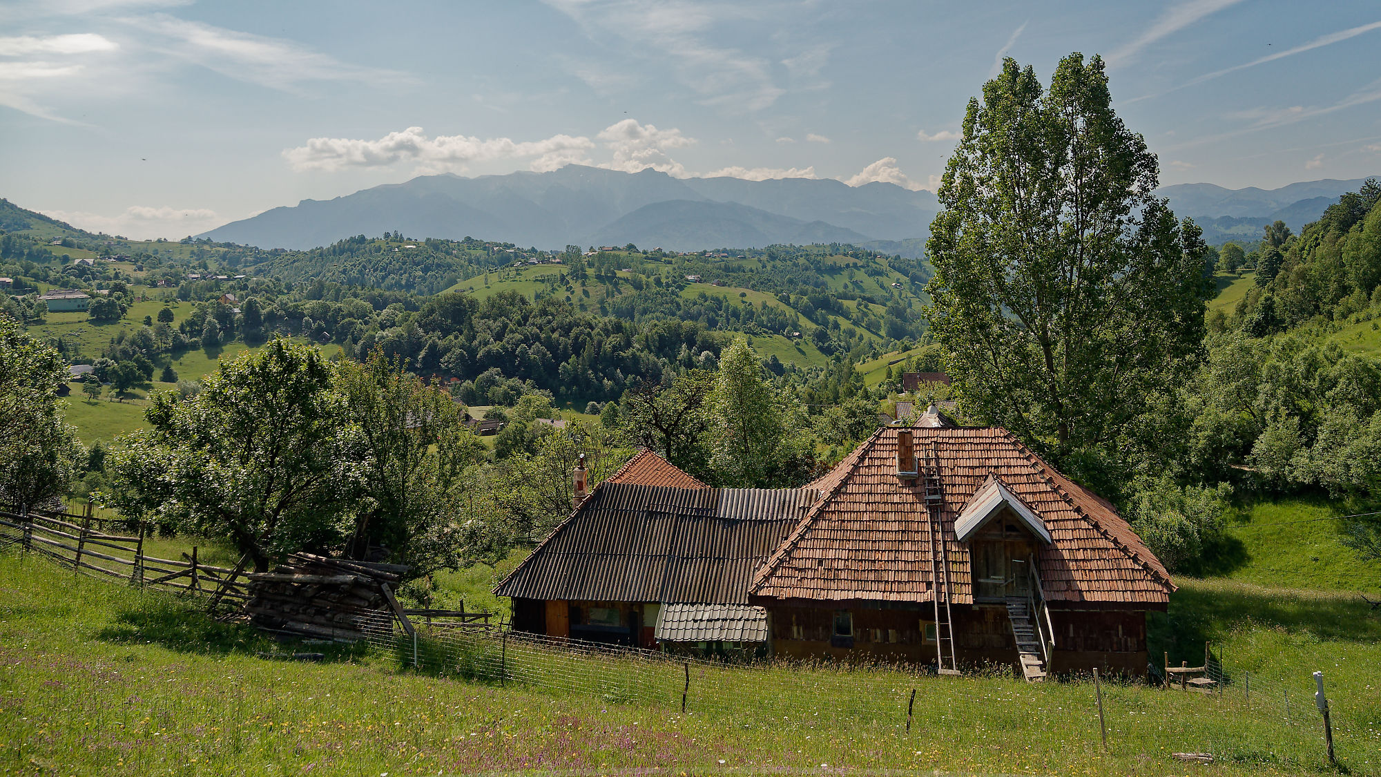 Rumänische Landschaft: Bauernhaus in Piatra Craiului Gebirge, grüne Hügel und Wald. Natururlaub in Rumänien.