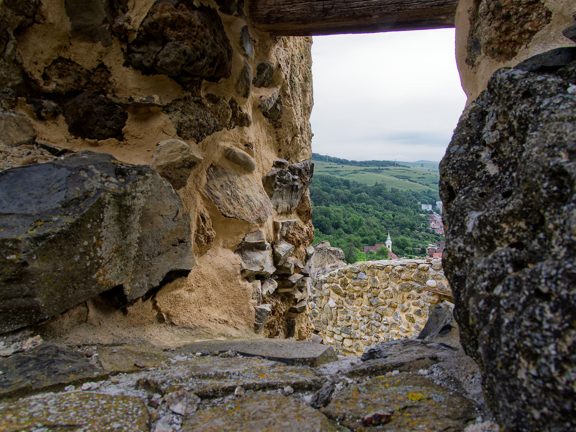 Blick aus Burg Rupea, Rumänien. Mittelalterliche Festungsmauer, Landschaft mit Wald und Dorf im Hintergrund. Reiseziel.