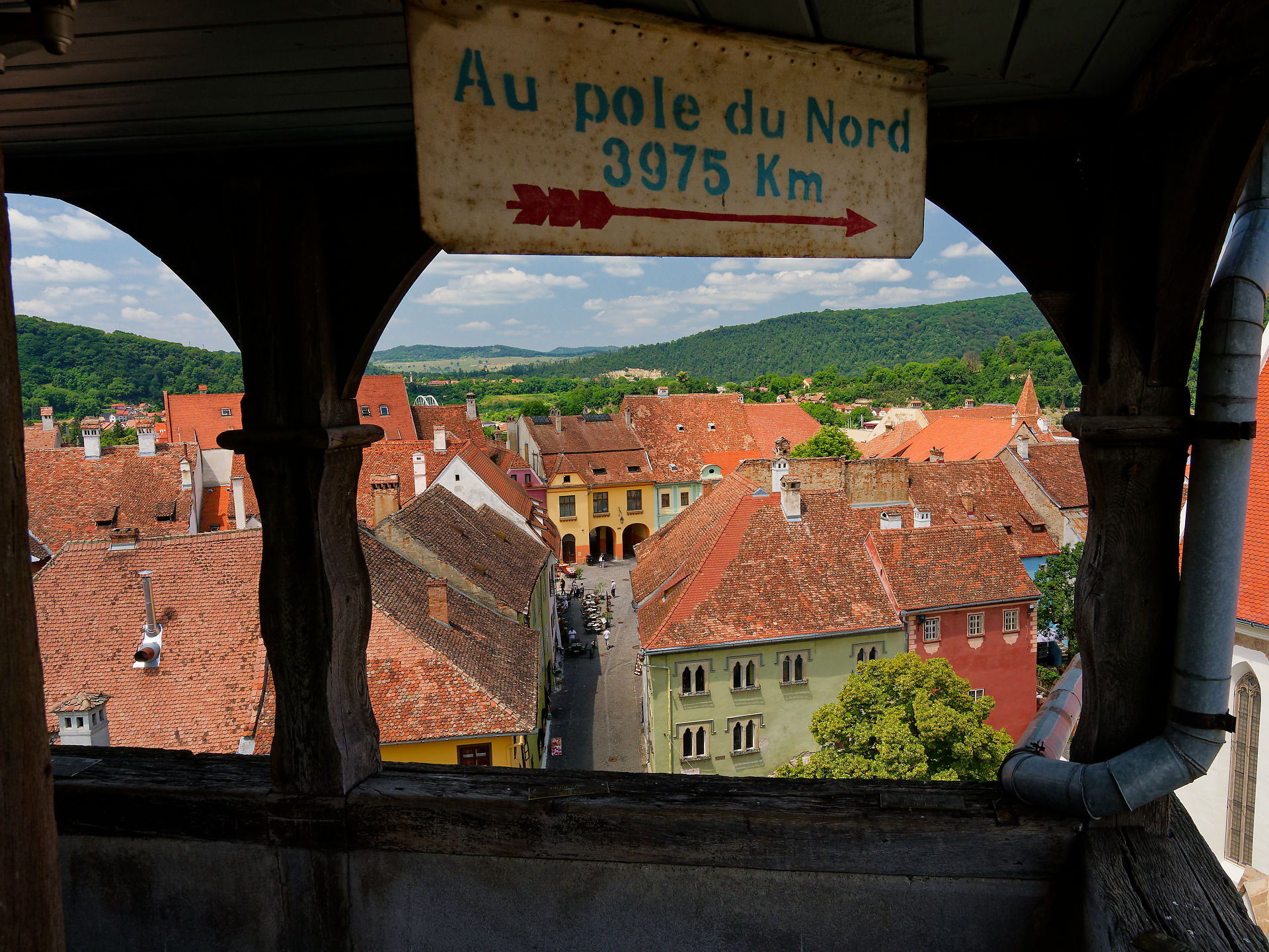 Sighisoara, Rumänien: Blick von oben auf die Altstadt mit roten Dächern und Wegweiser zum Nordpol. Mittelalterliche Architektur.