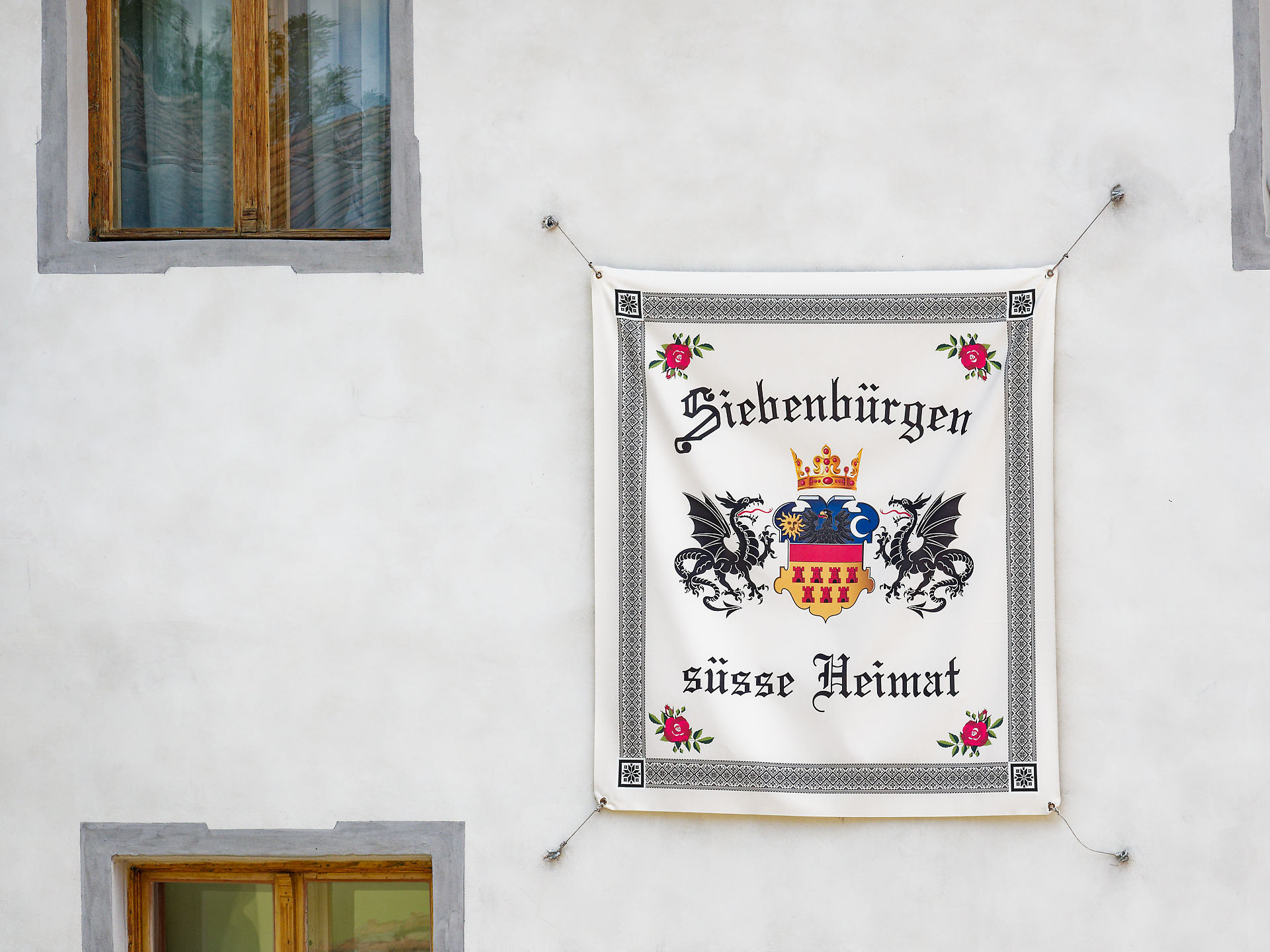 Siebenbürgen Banner an Hauswand. Wappen mit Drachen und Krone, Süsse Heimat. Rumänien, Sighisoara.
