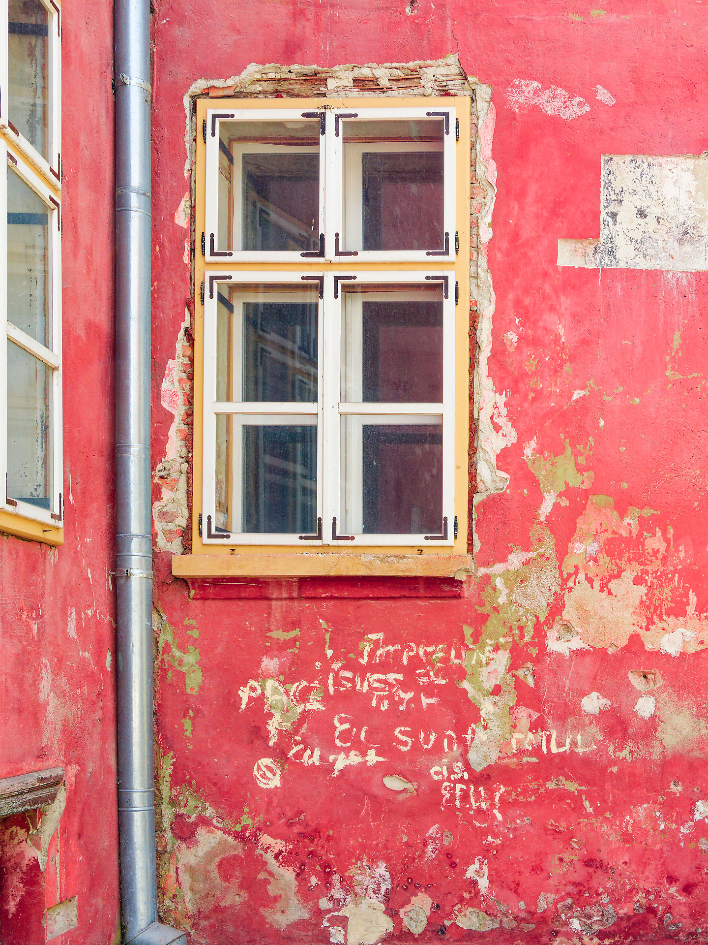 Rote Wand in Sighisoara, Rumänien, mit Fenster und Graffiti. Architektur und Stadtbild.