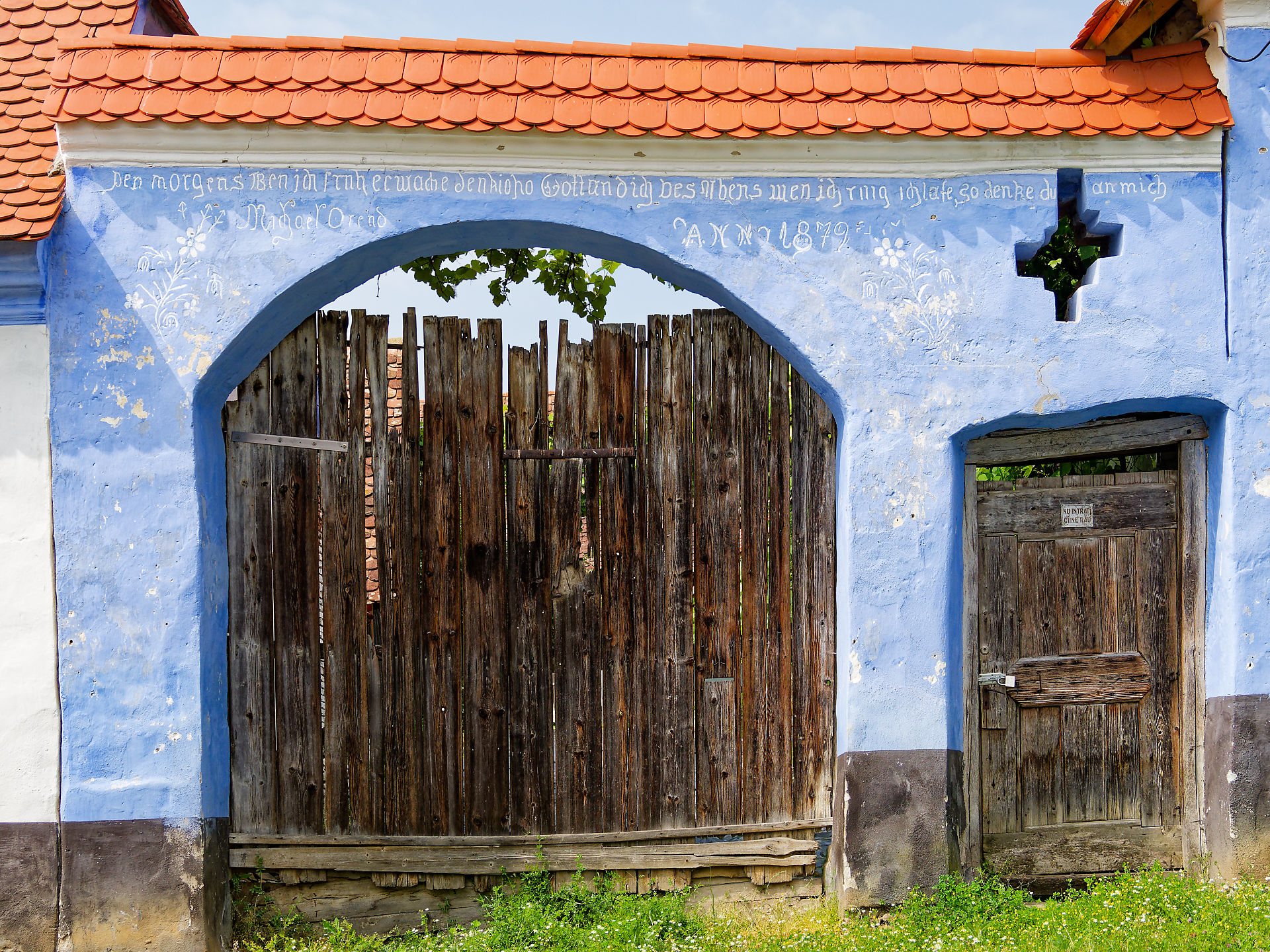 Viscri, Rumänien: Blaues Tor mit Inschrift und Holztür, rustikal, historisch.