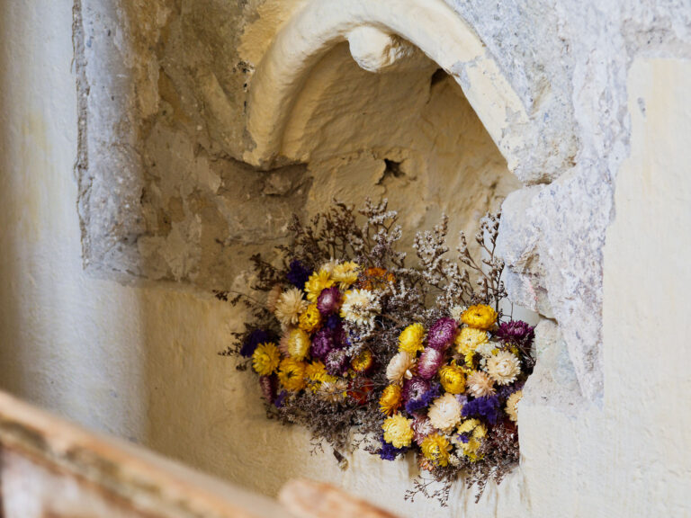 Blumen in einer Nische, Viscri, Rumänien. Mittelalterliche Architektur, gelbe und lila Blumenarrangements.