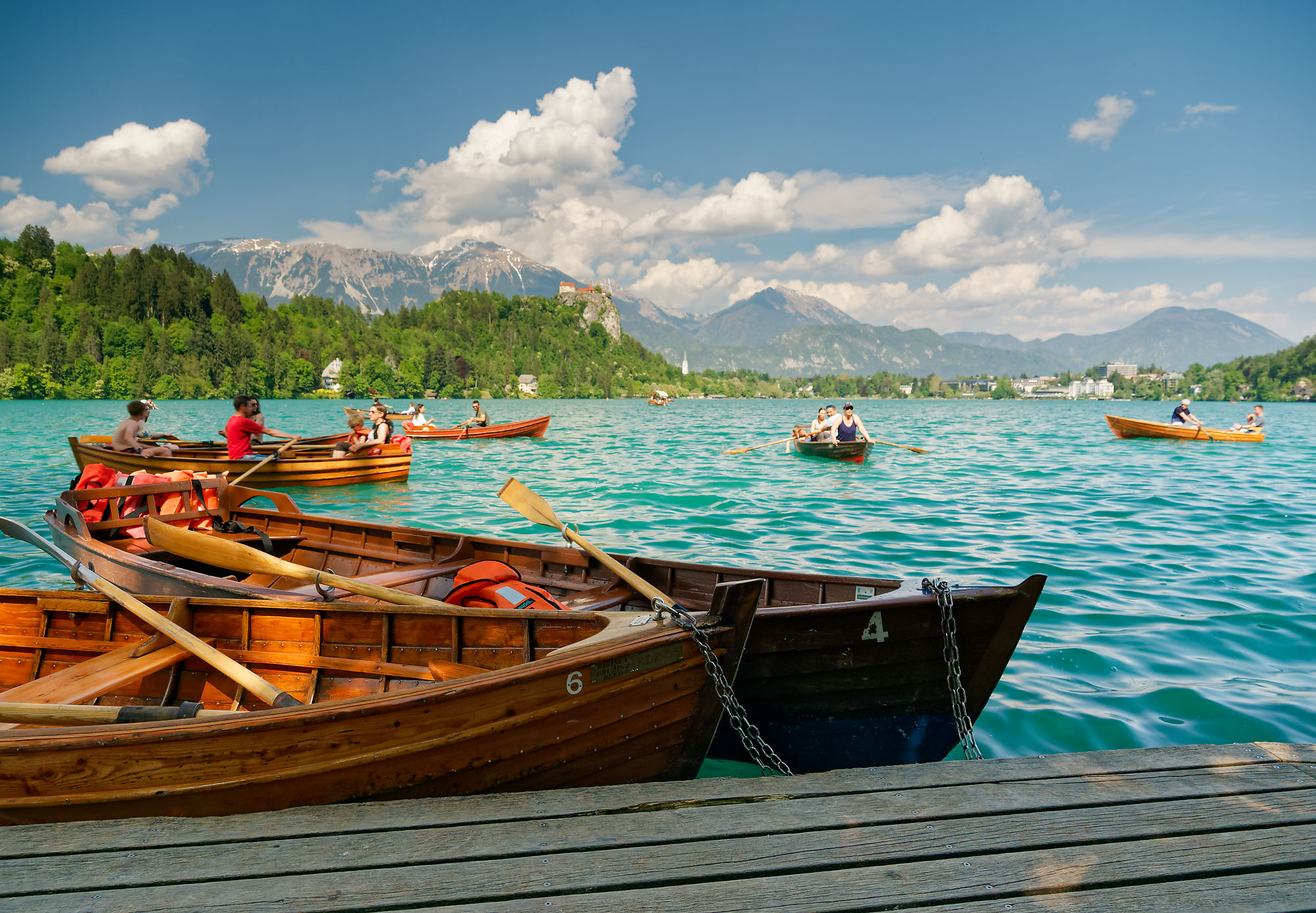 Bleder See, Slowenien: Ruderboote auf türkisfarbenem Wasser vor Bergkulisse. Urlaub am See.