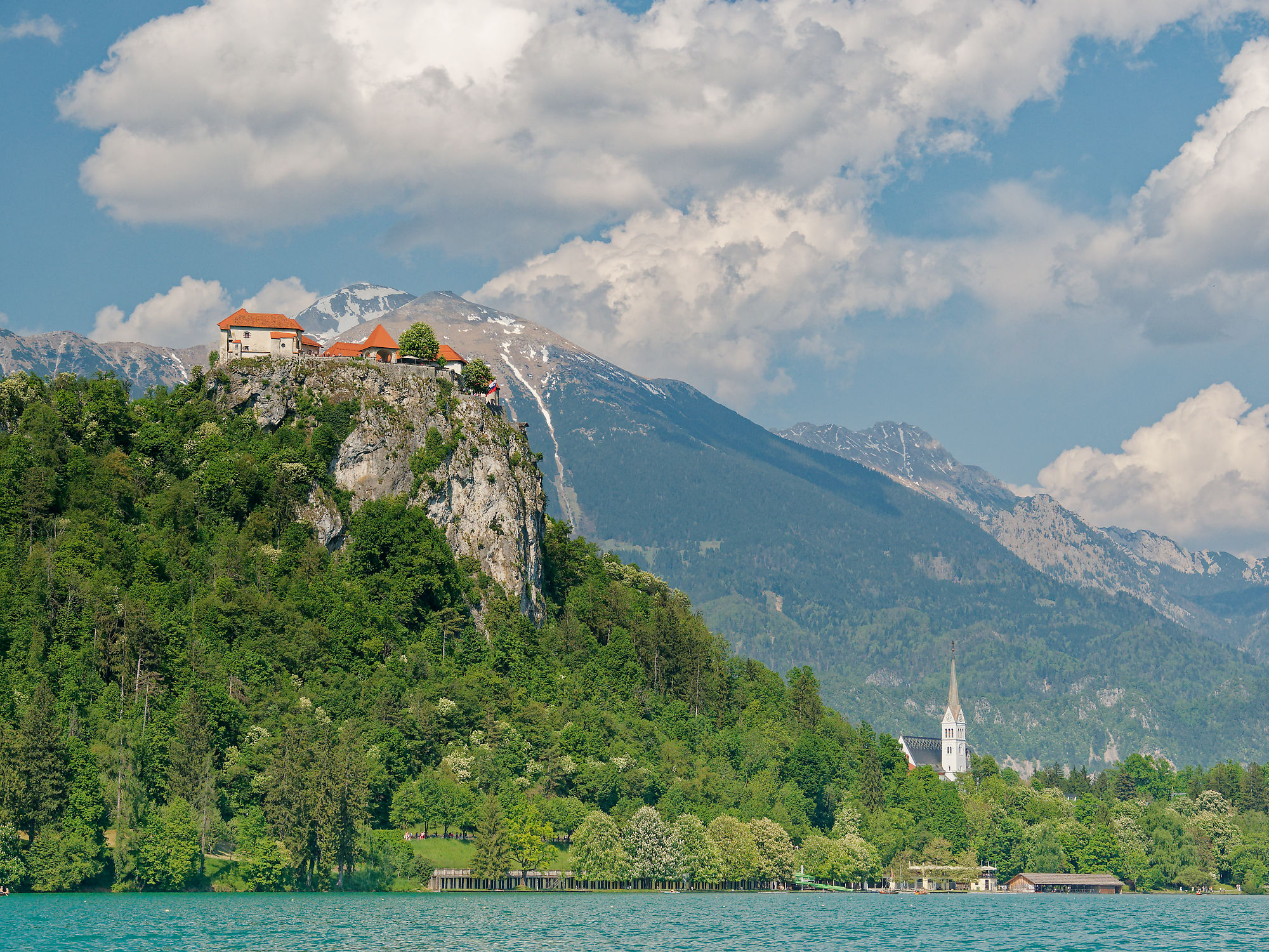Bled, Slowenien: Berglandschaft mit Burg und grünen Wäldern unter blauem Himmel. Reiseziel.