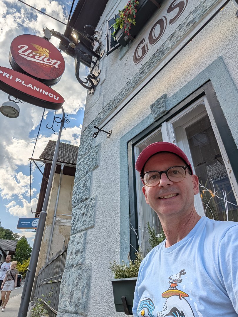 Gostilna Pri Planincu, Bled. Union Biergarten Schild und Tourist vor traditionellem slowenischen Gasthaus.