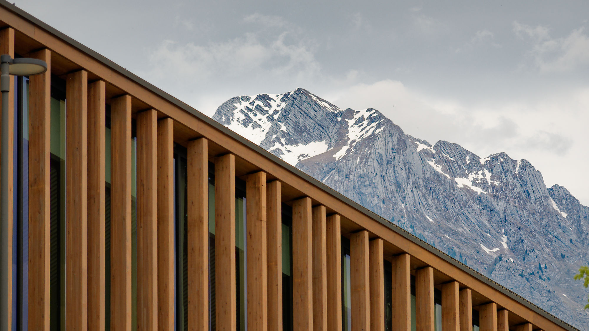 Fassade aus Holz in Slowenien vor Bergkulisse. Soca-Tal Architektur.