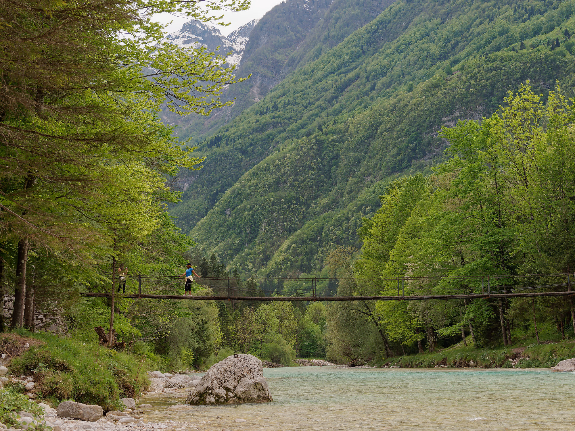 Soca Fluss, Slowenien: Hängebrücke über türkisem Wasser. Berge und grüne Natur im Soca Tal.