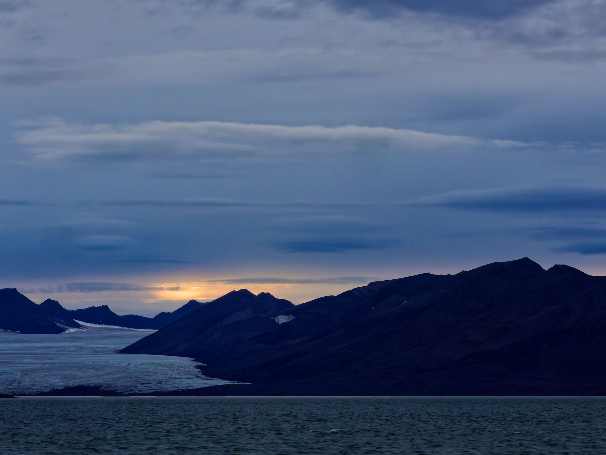 Isfjord, Spitzbergen: Gletscher und Berge unter bewölktem Himmel. Arktische Landschaft.