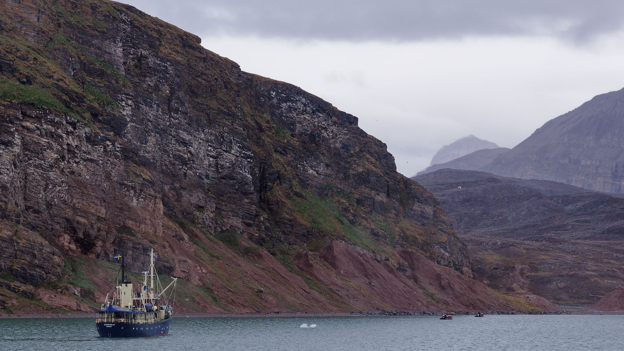 Bootstour im Kongsfjord, Spitzbergen. Arktische Landschaft mit Bergen und Schiff.