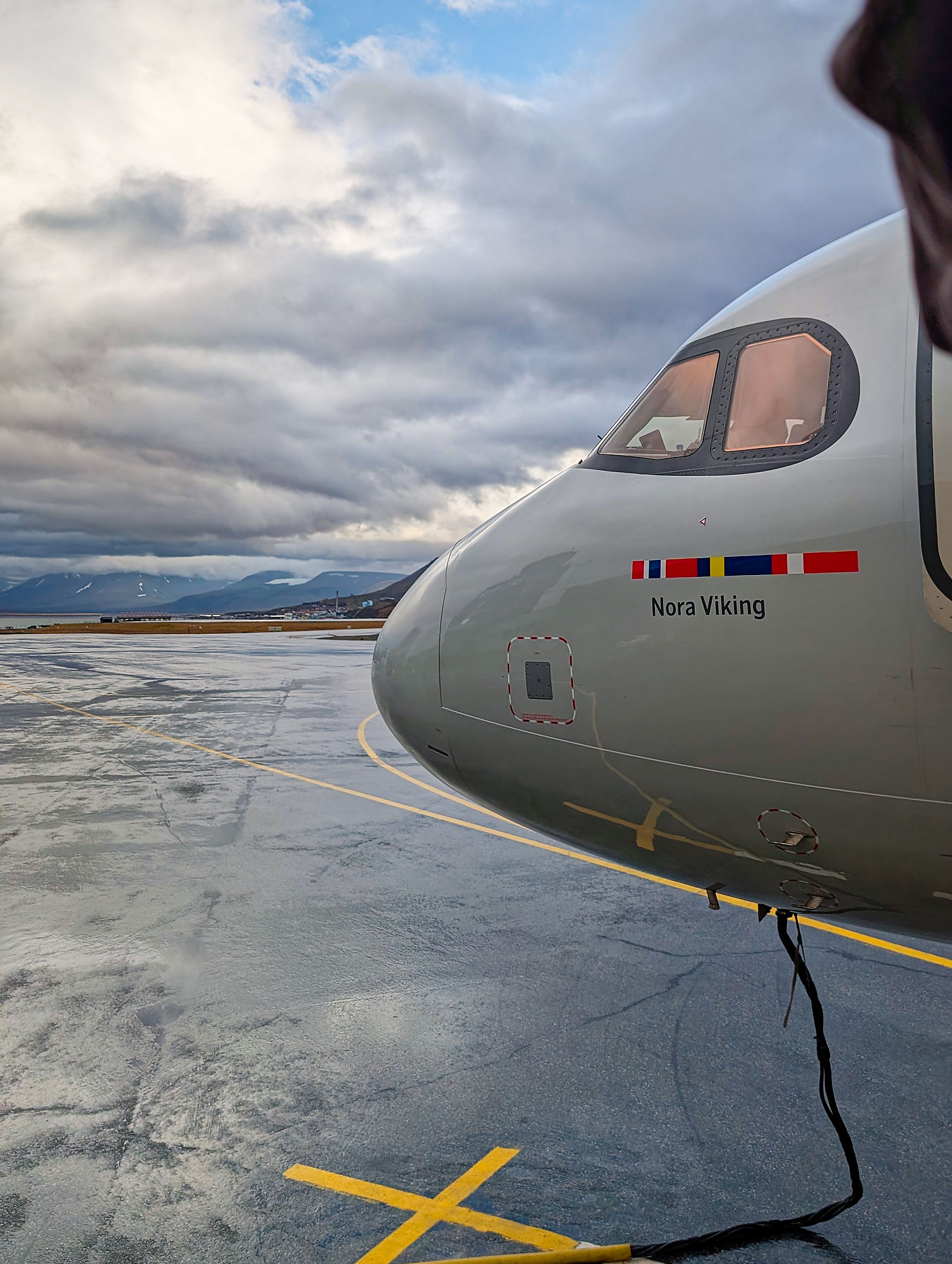 Flugzeug Nora Viking am Flughafen. Cockpit-Ansicht, nasse Landebahn, bewölkter Himmel. Flugreise-Impression.