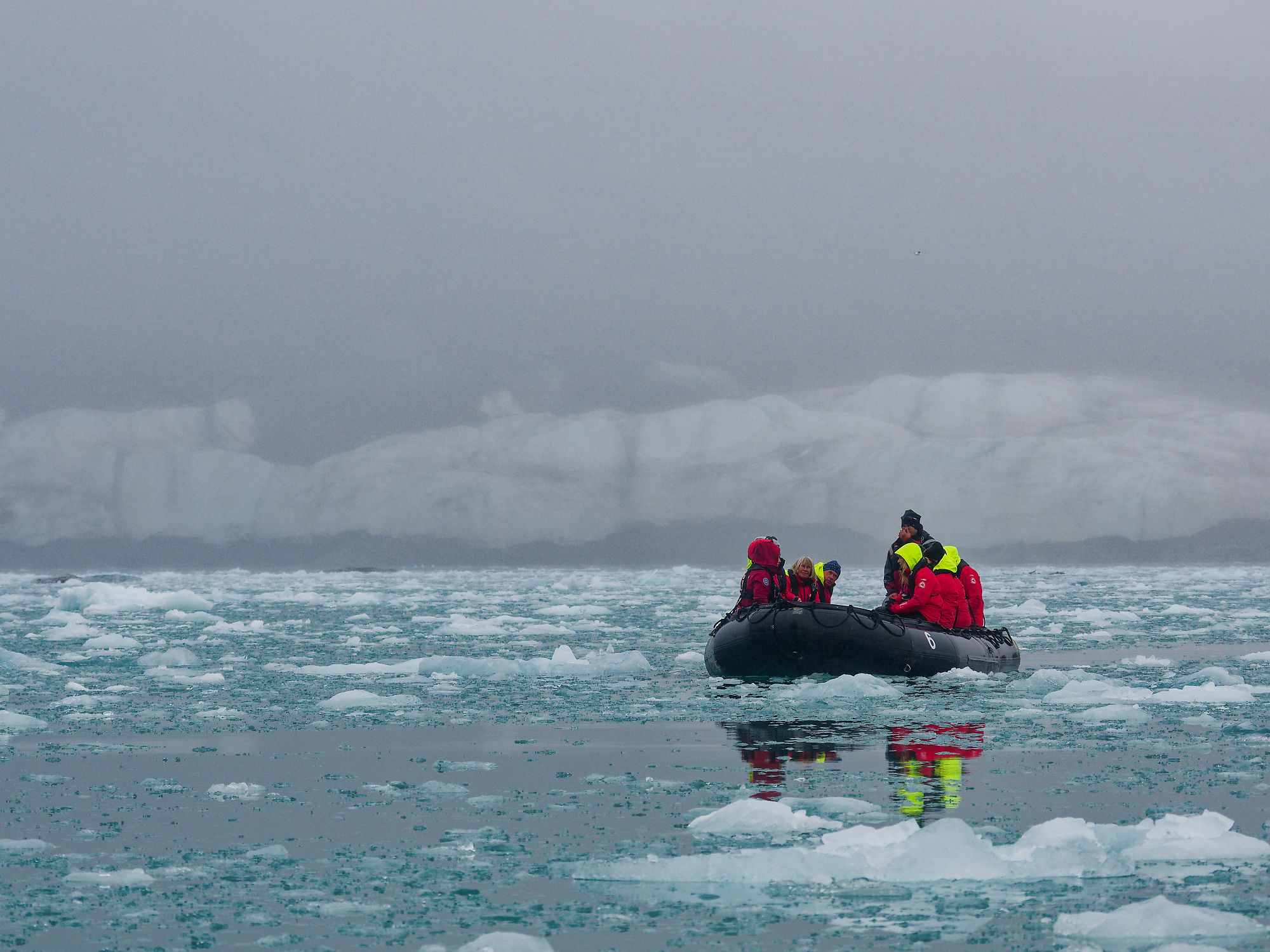 Schlauchboot-Tour im Liefdefjorden, Spitzbergen. Eisberge und Touristen in arktischer Landschaft.