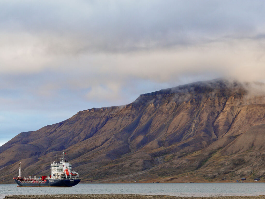 Longyearbyen, Spitzbergen: Schiff vor Bergkulisse. Arktische Landschaft mit Nebel.