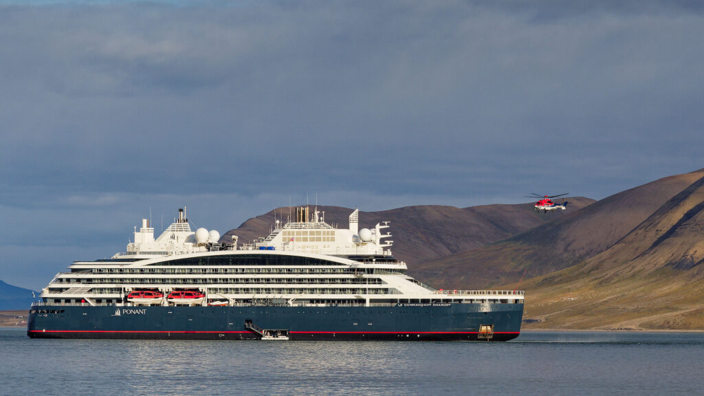 Kreuzfahrtschiff in Longyearbyen, Spitzbergen. Helikopter im Hintergrund. Arktis-Kreuzfahrt.